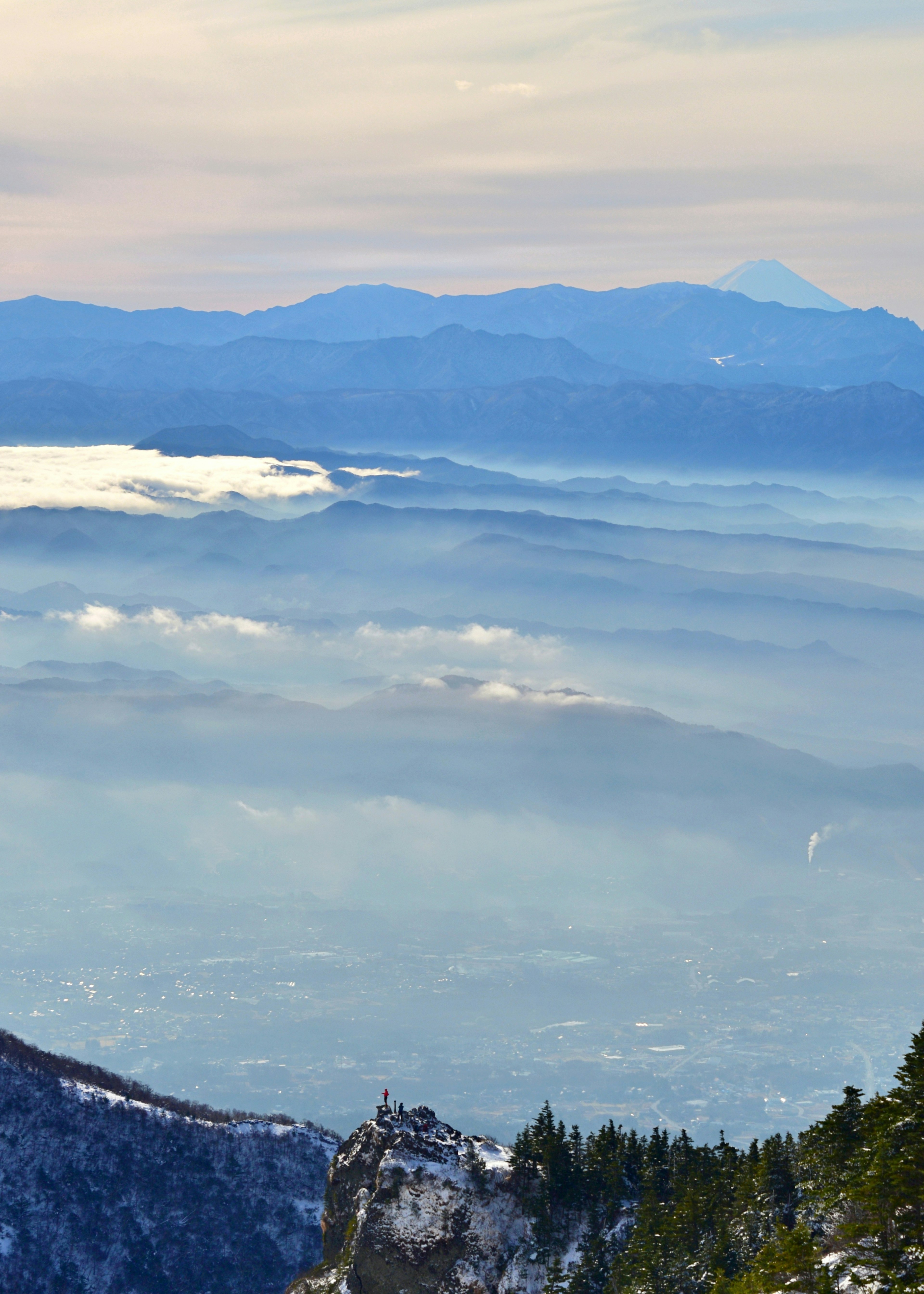 Schneebedeckte Berge mit einem im Nebel gehüllten Tal