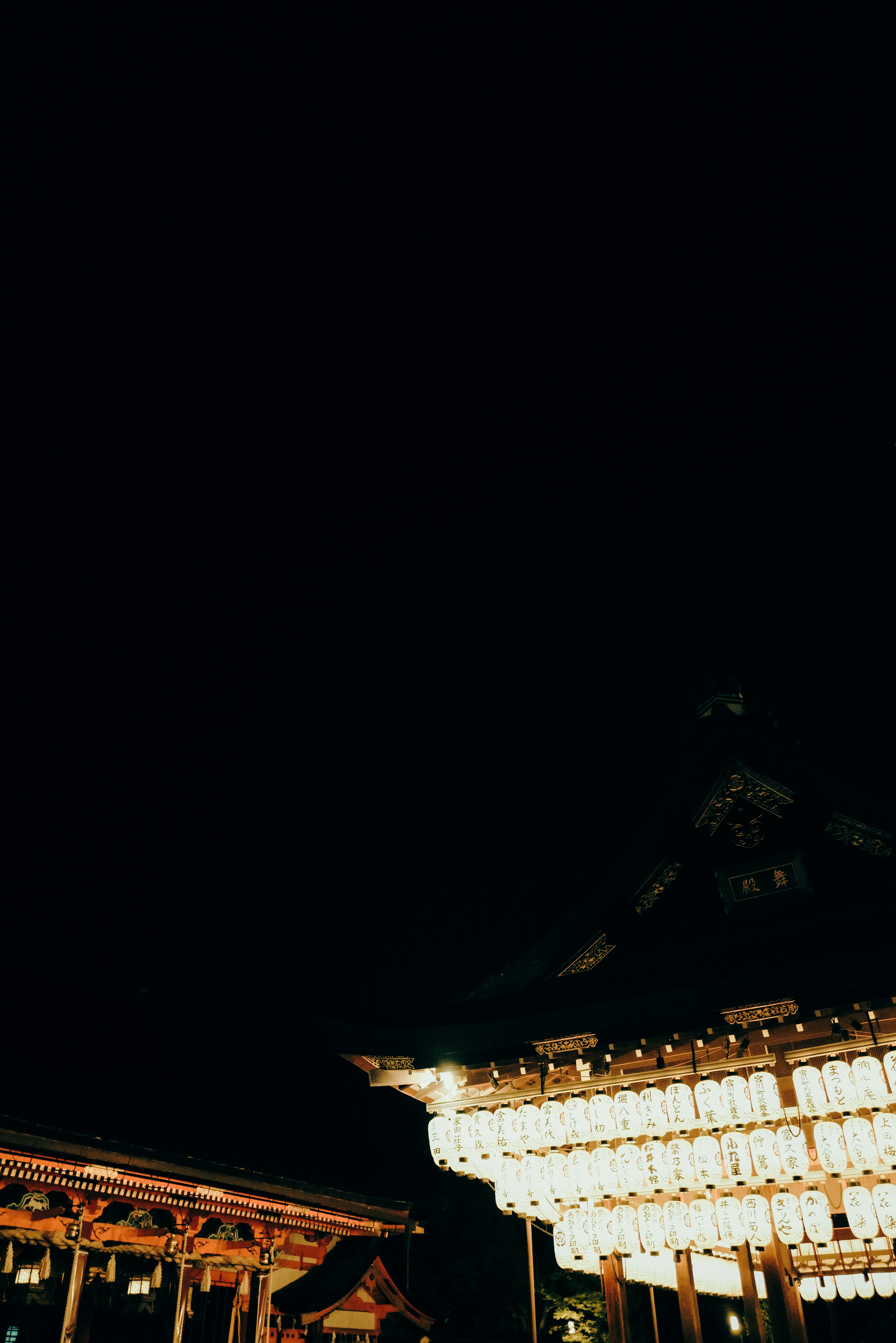 Traditional Japanese building illuminated at night with lanterns