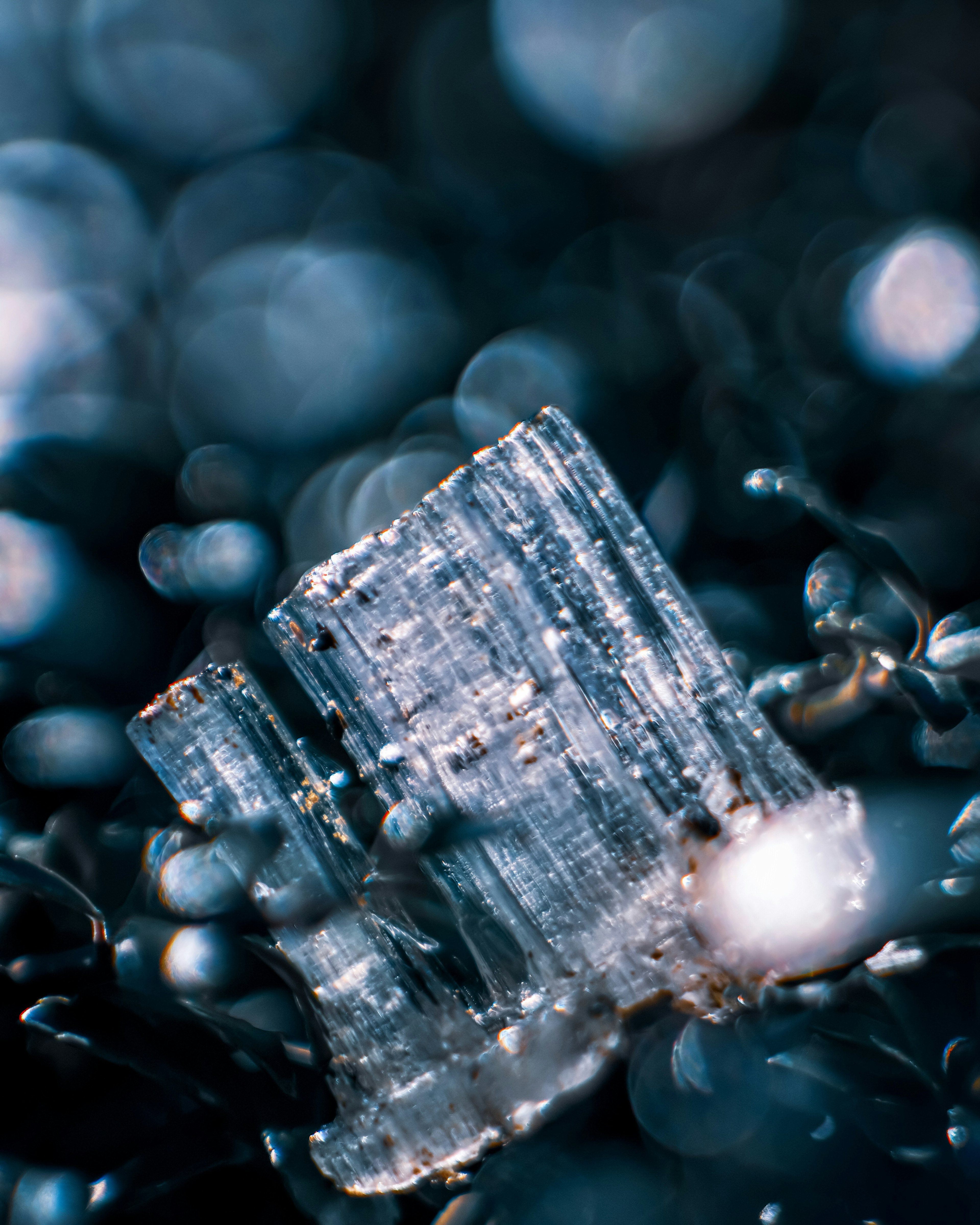 Close-up of a transparent crystal against a blue background