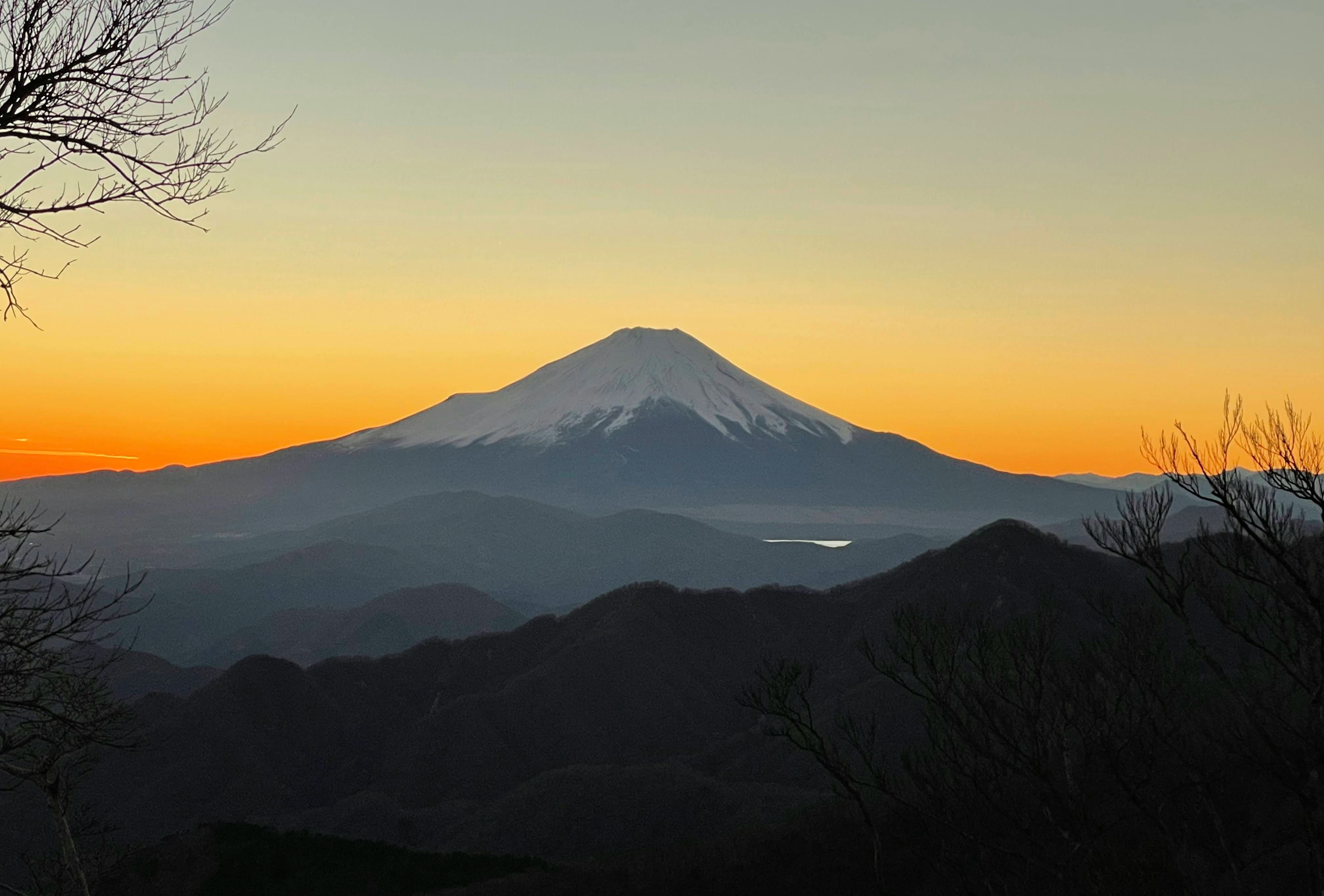 Hermosa vista del monte Fuji al atardecer rodeado de montañas y un lago sereno