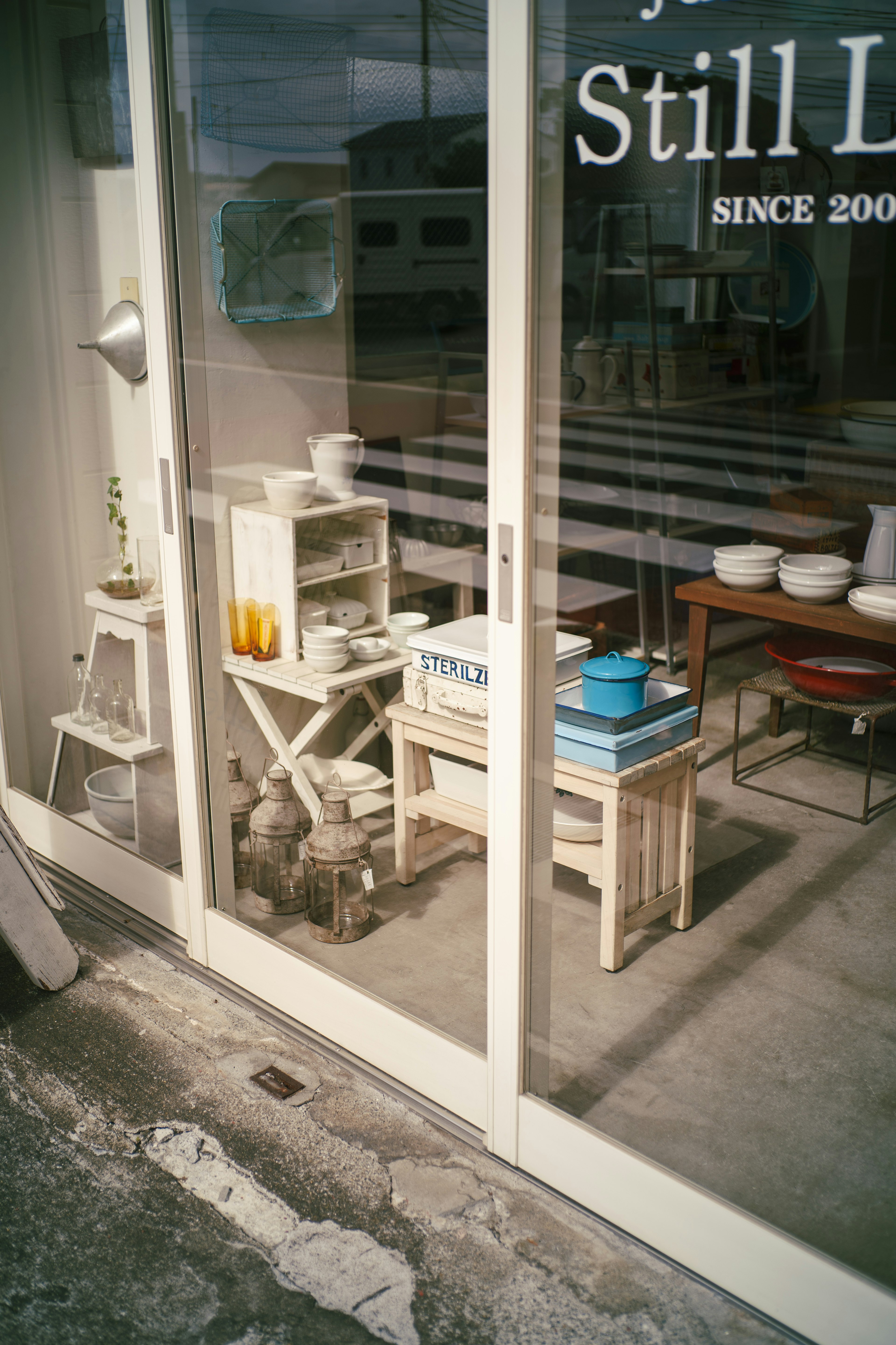 Stylish store entrance with white furniture and tableware displayed