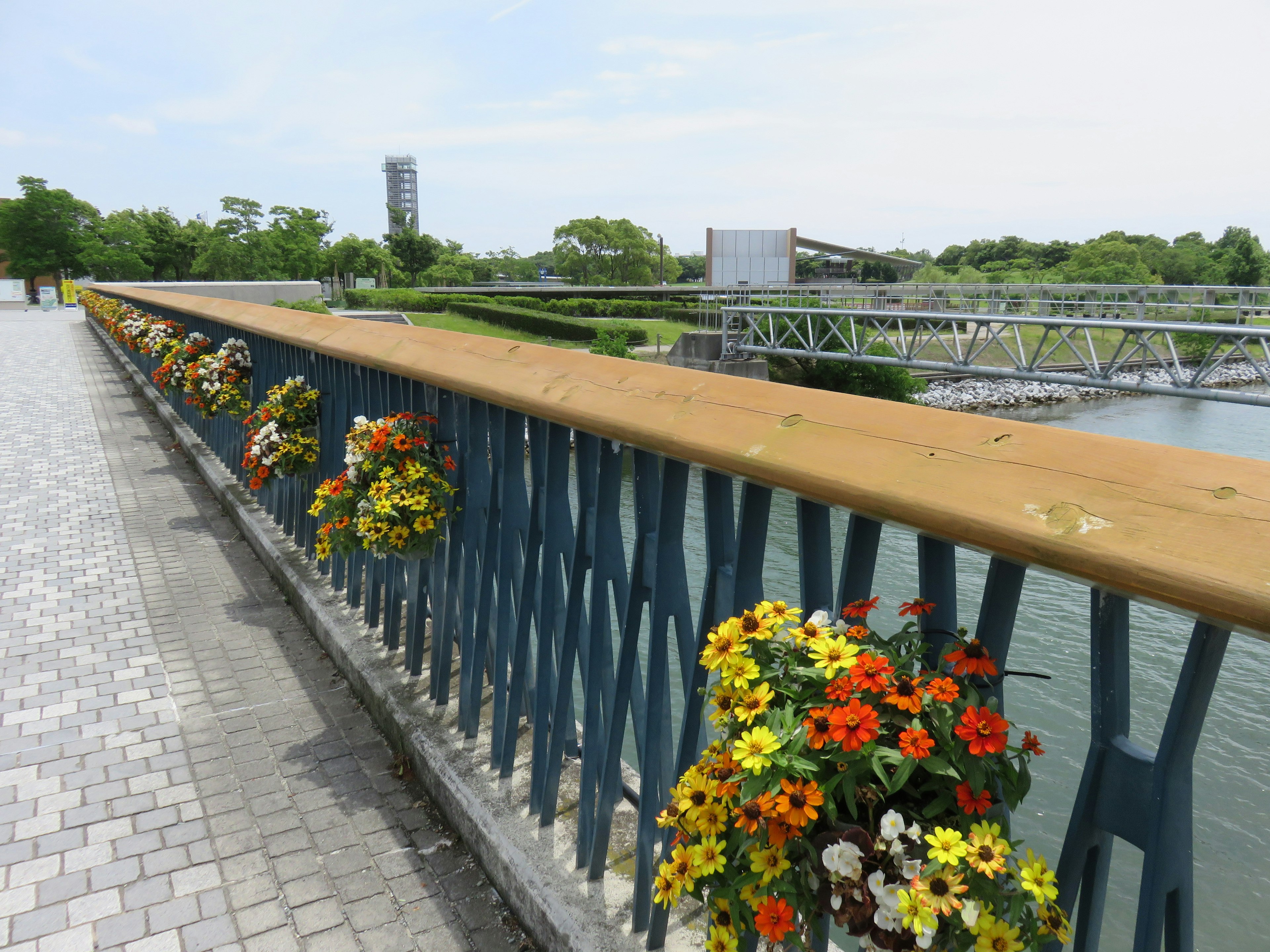 Bridge railing adorned with colorful flowers and river view