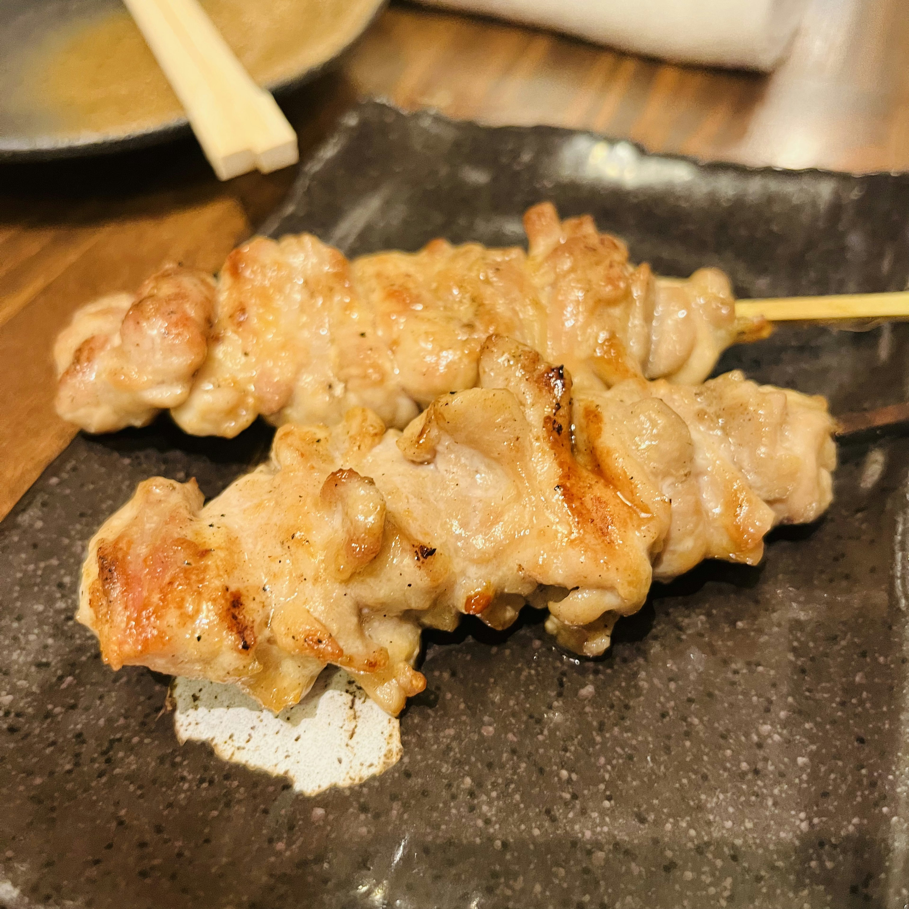 Brochetas de pollo a la parrilla en un plato negro