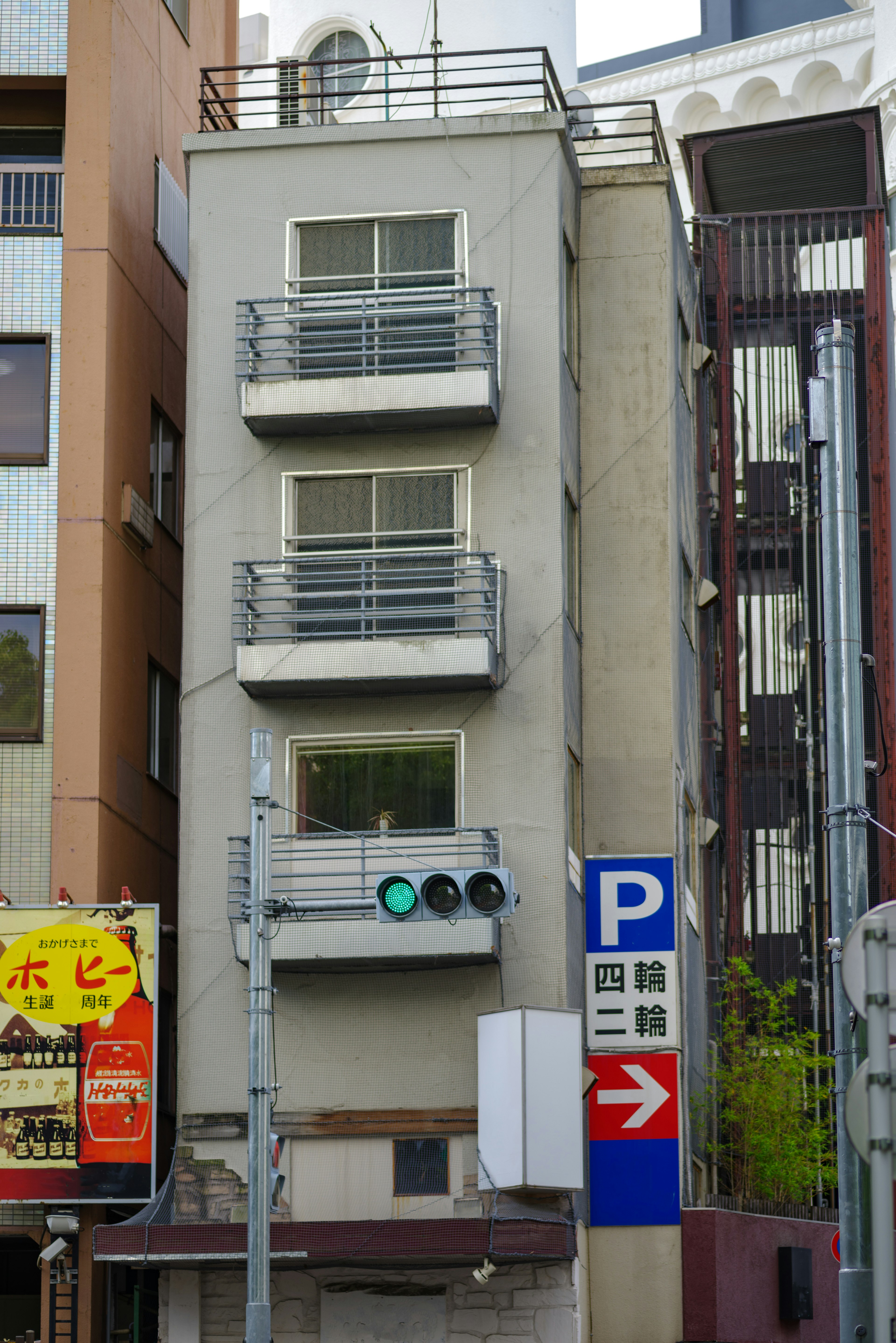 細長いビルの外観とバルコニーが目立つ都市の風景