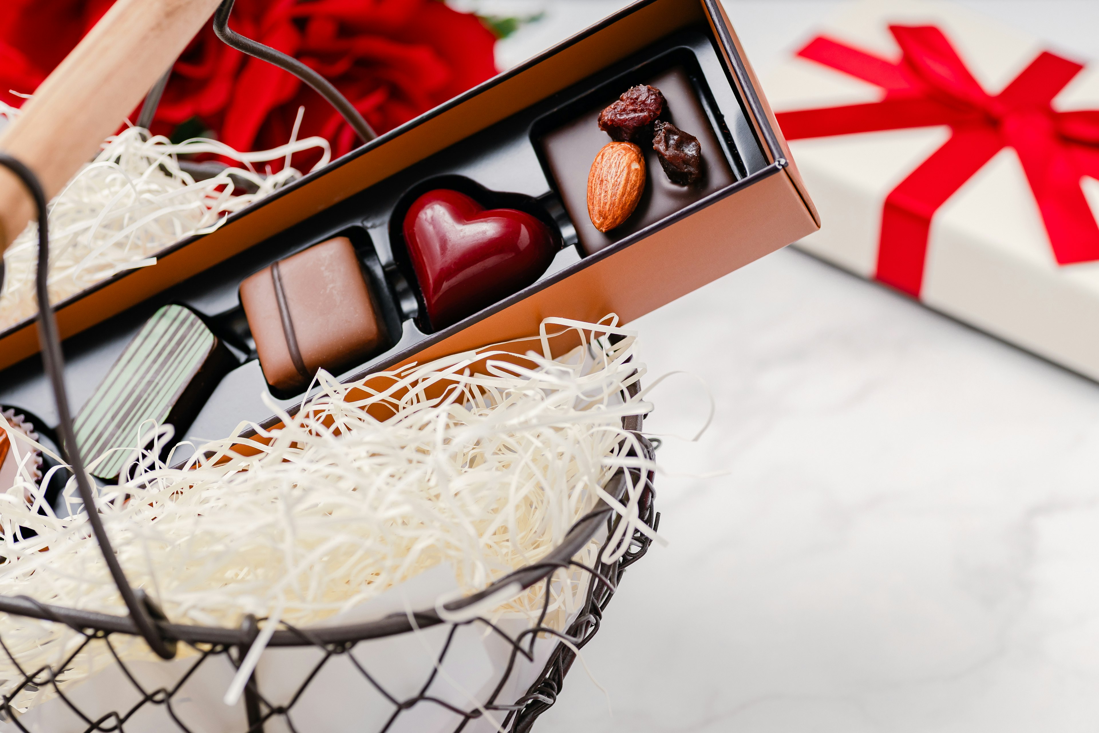 Gift basket featuring red roses and a box of chocolates