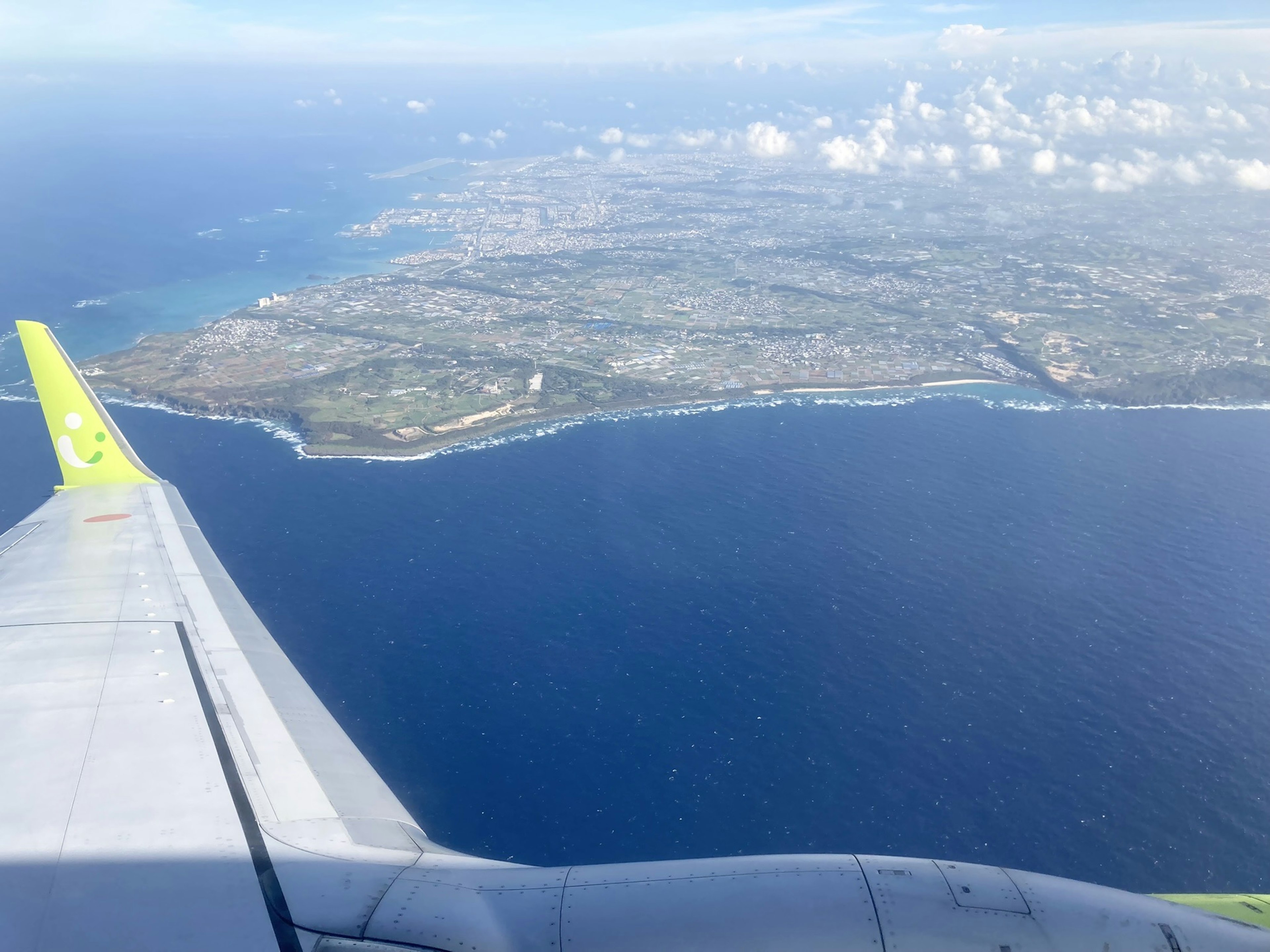 View of the ocean and island from an airplane wing