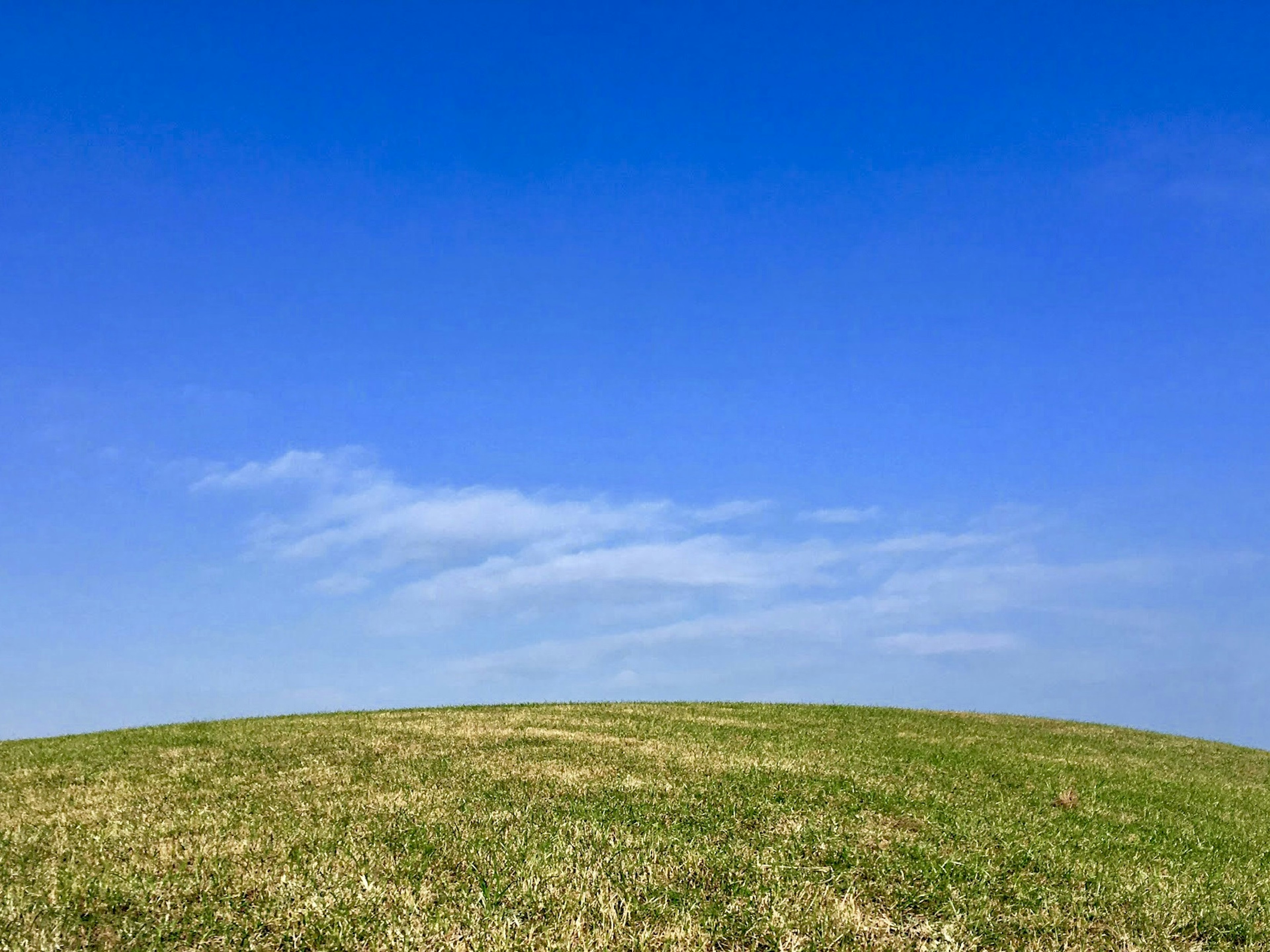 Pemandangan dengan langit biru dan bukit hijau