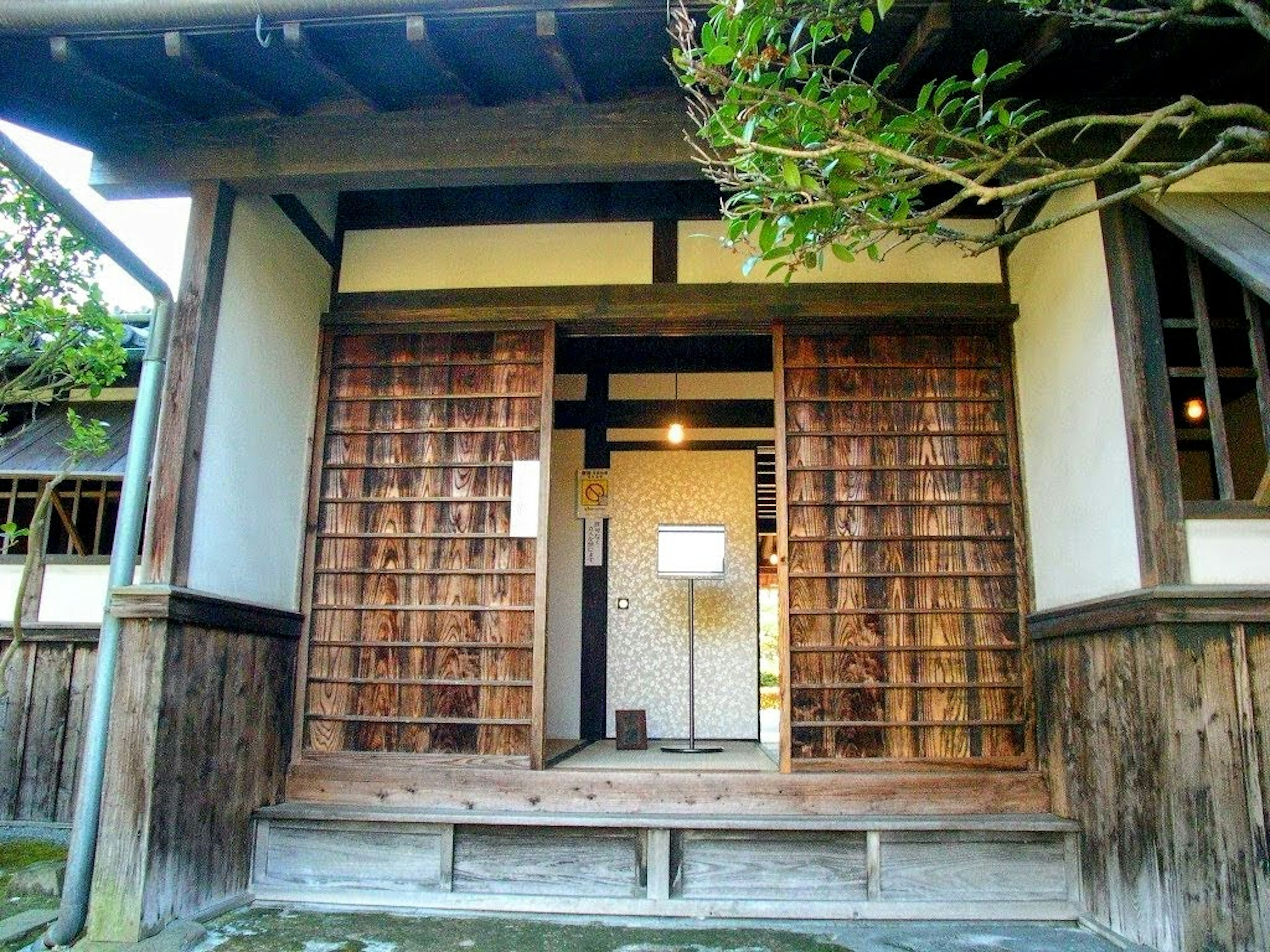 Eingang eines traditionellen japanischen Hauses mit Holzschiebetüren und natürlichem Licht