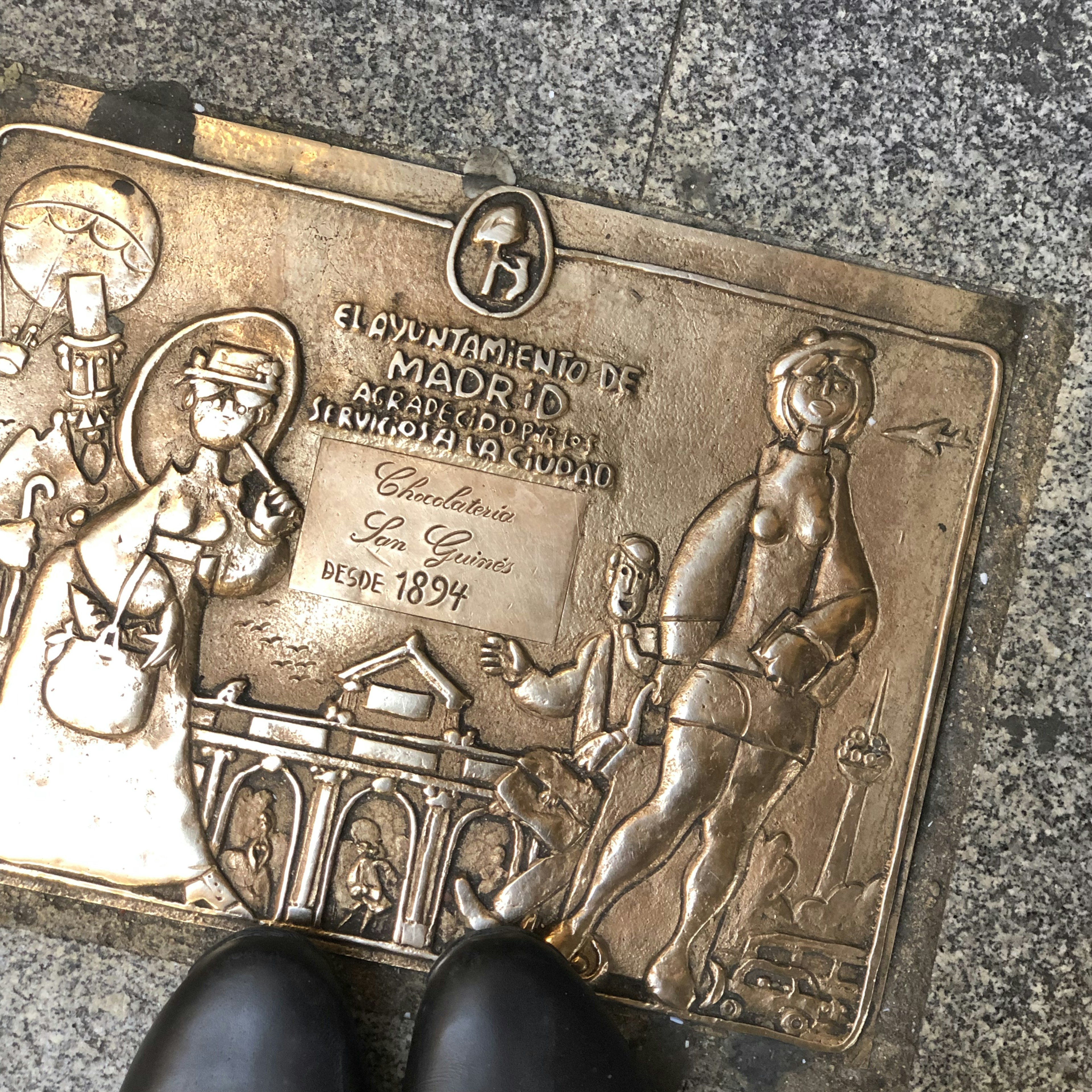 Bronzetafel des Rathauses von Madrid mit historischen Figuren und Architektur