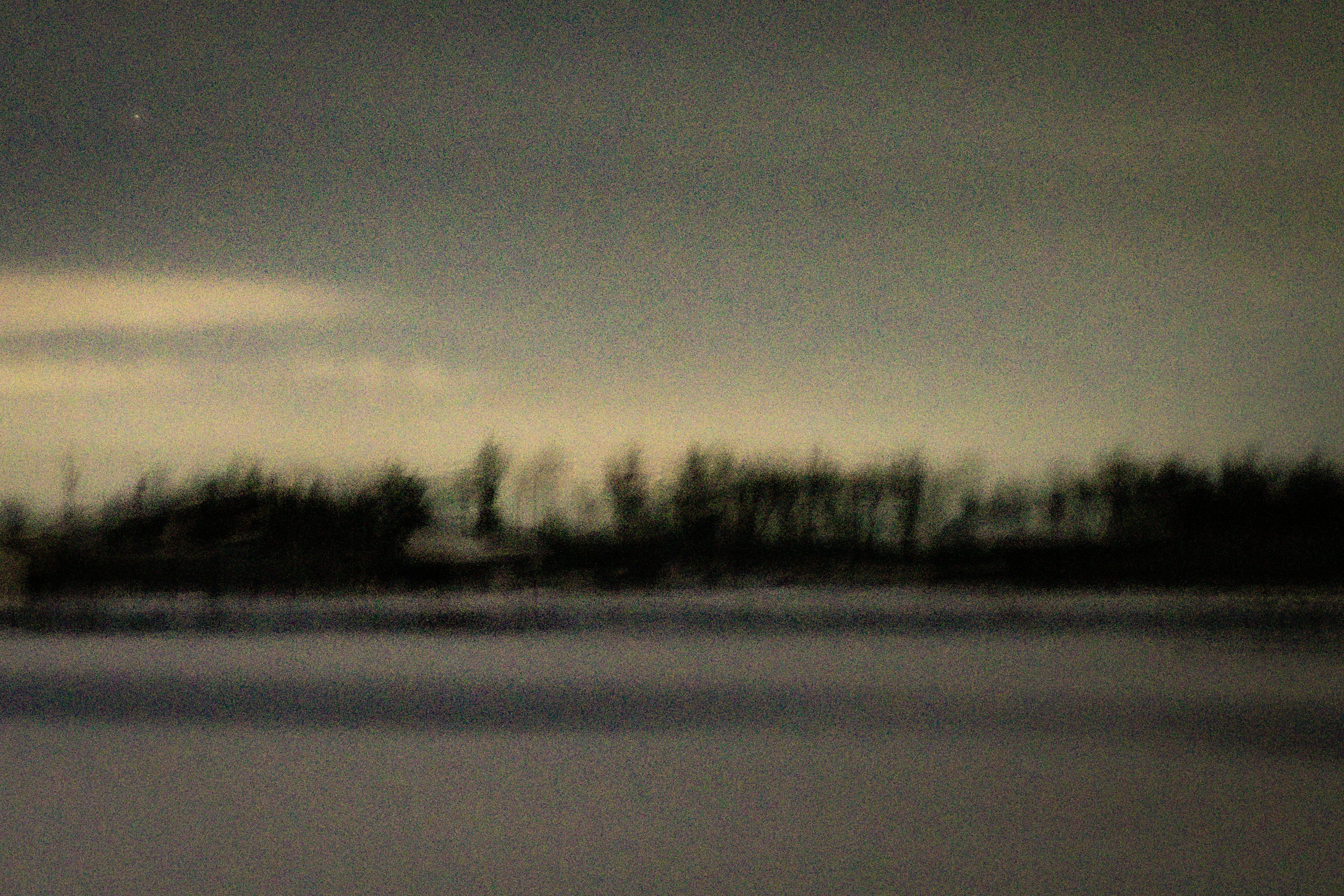 Verschwommene Winterlandschaft mit kühlem Himmel und schneebedecktem Boden Bäume im Hintergrund