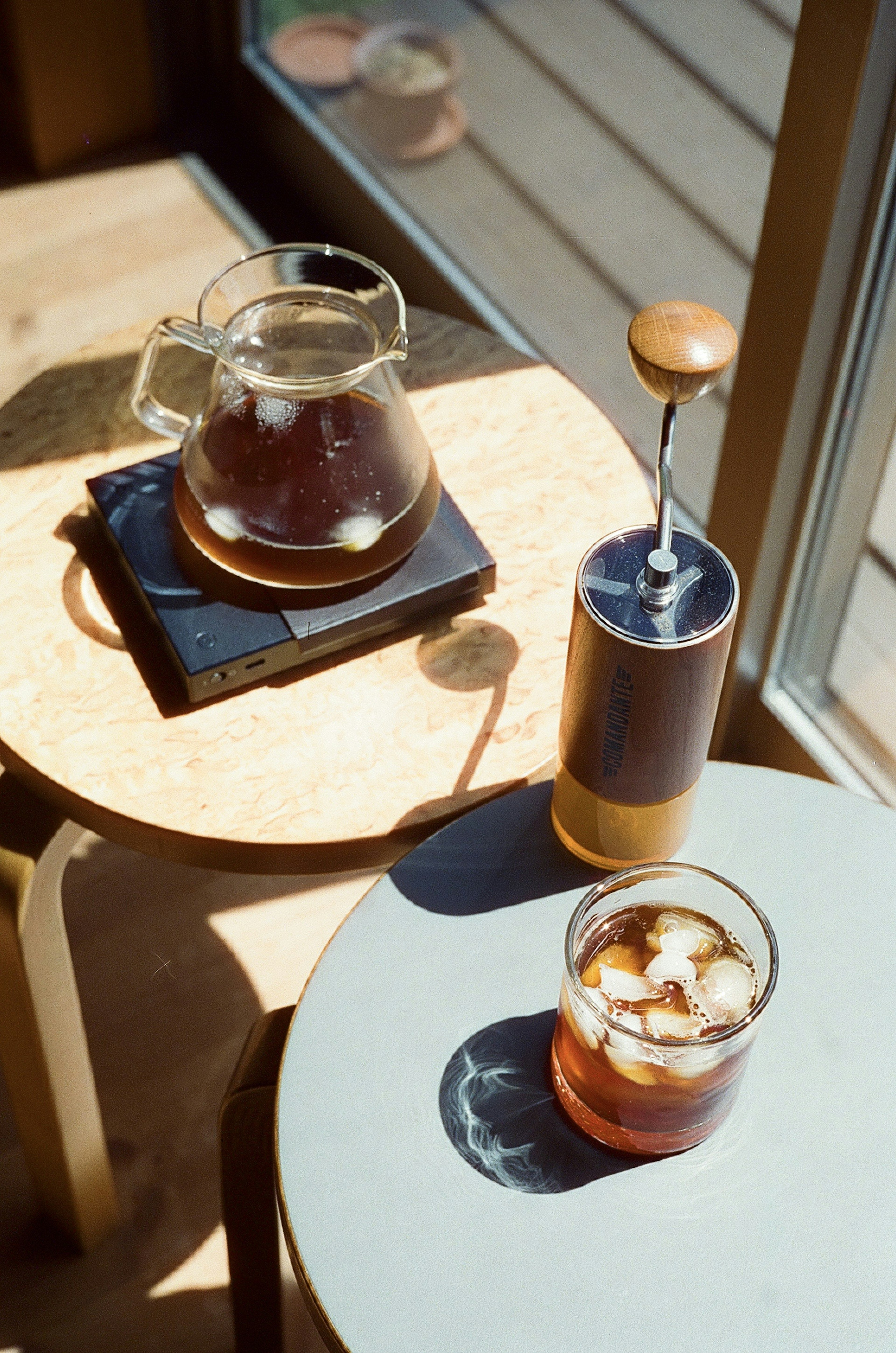 Un vaso de café helado y una cafetera en una mesa de café