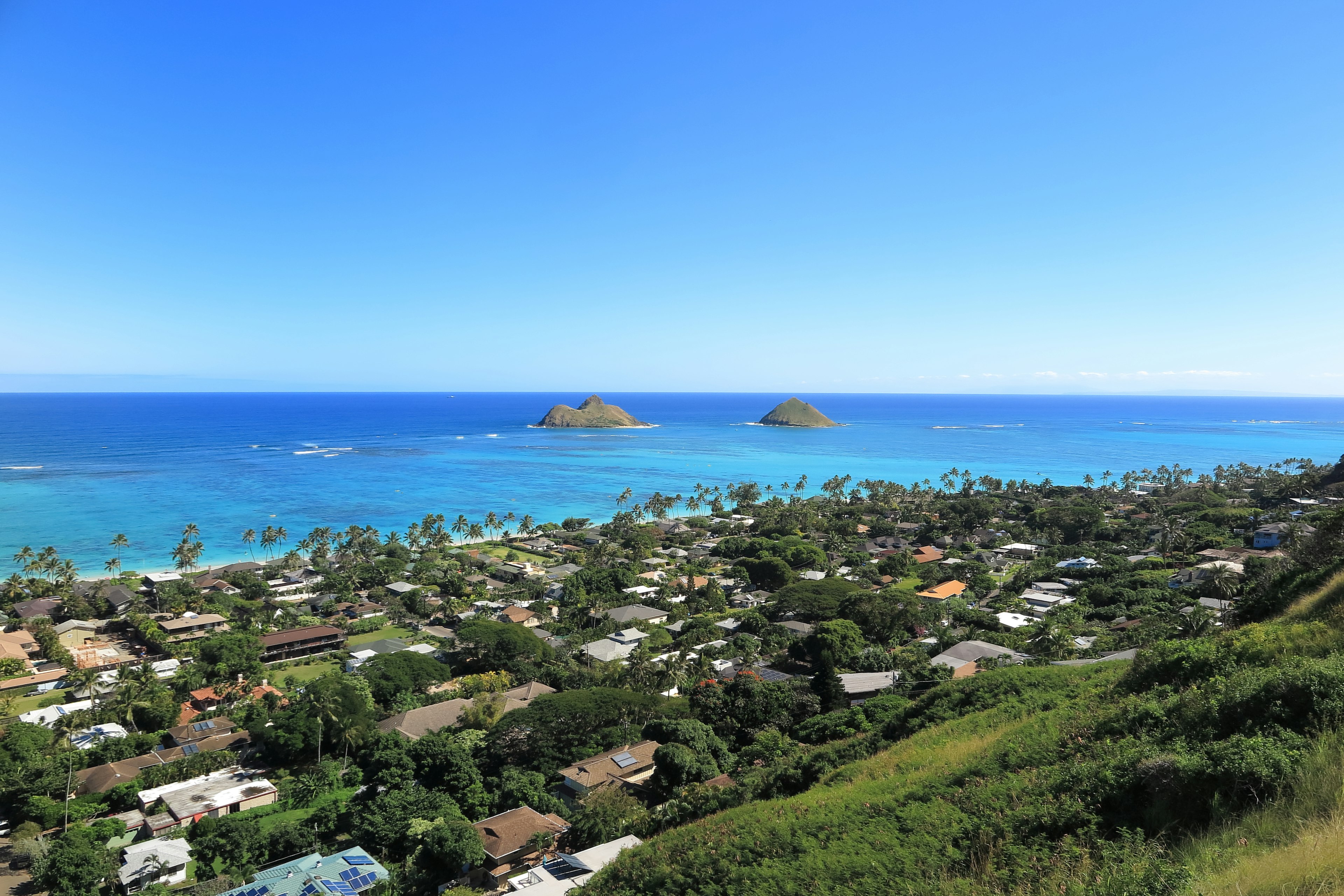 A picturesque view of blue ocean and sky with houses in Hawaii