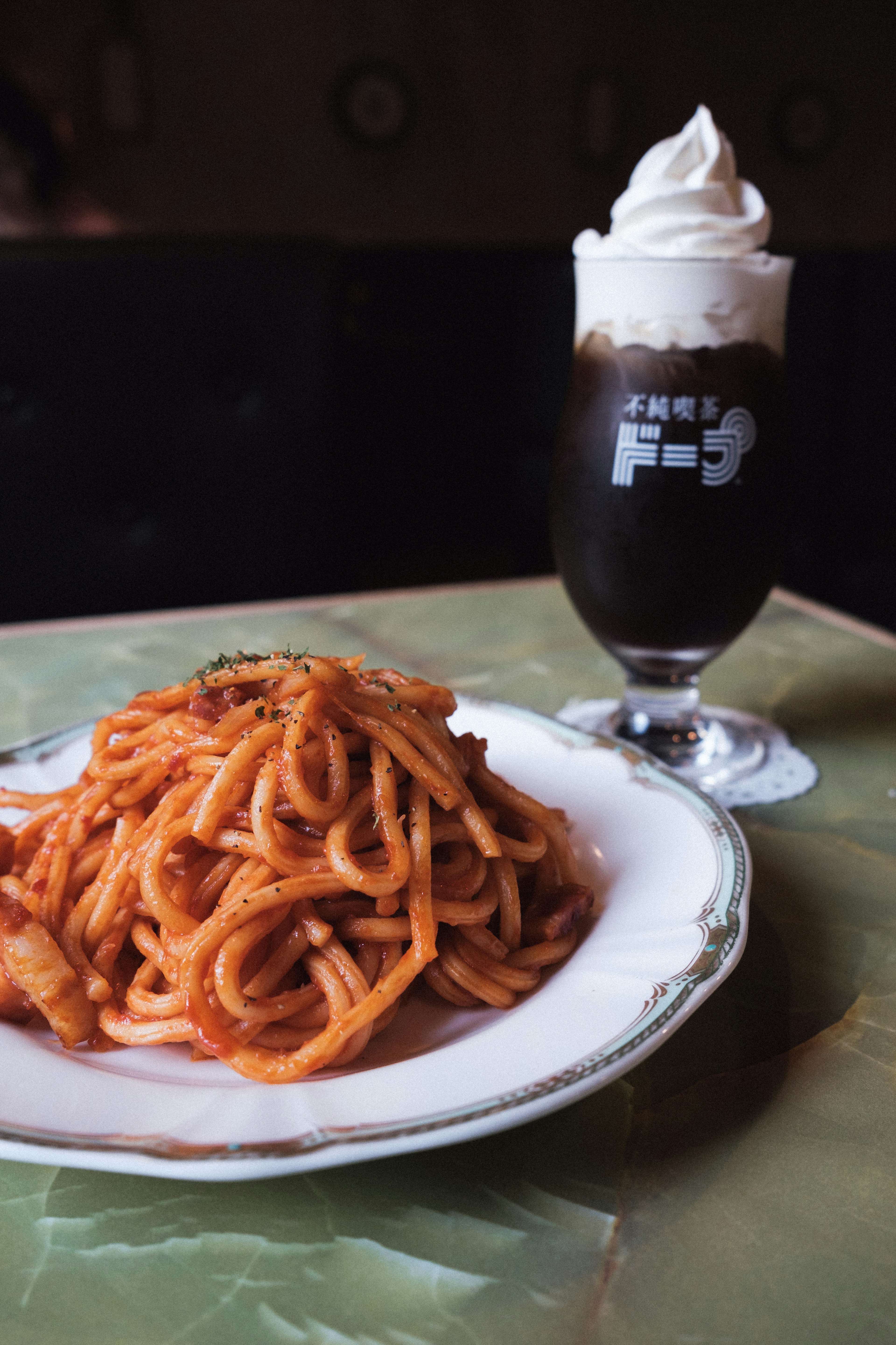 Piatto di spaghetti con una bevanda cremosa accanto