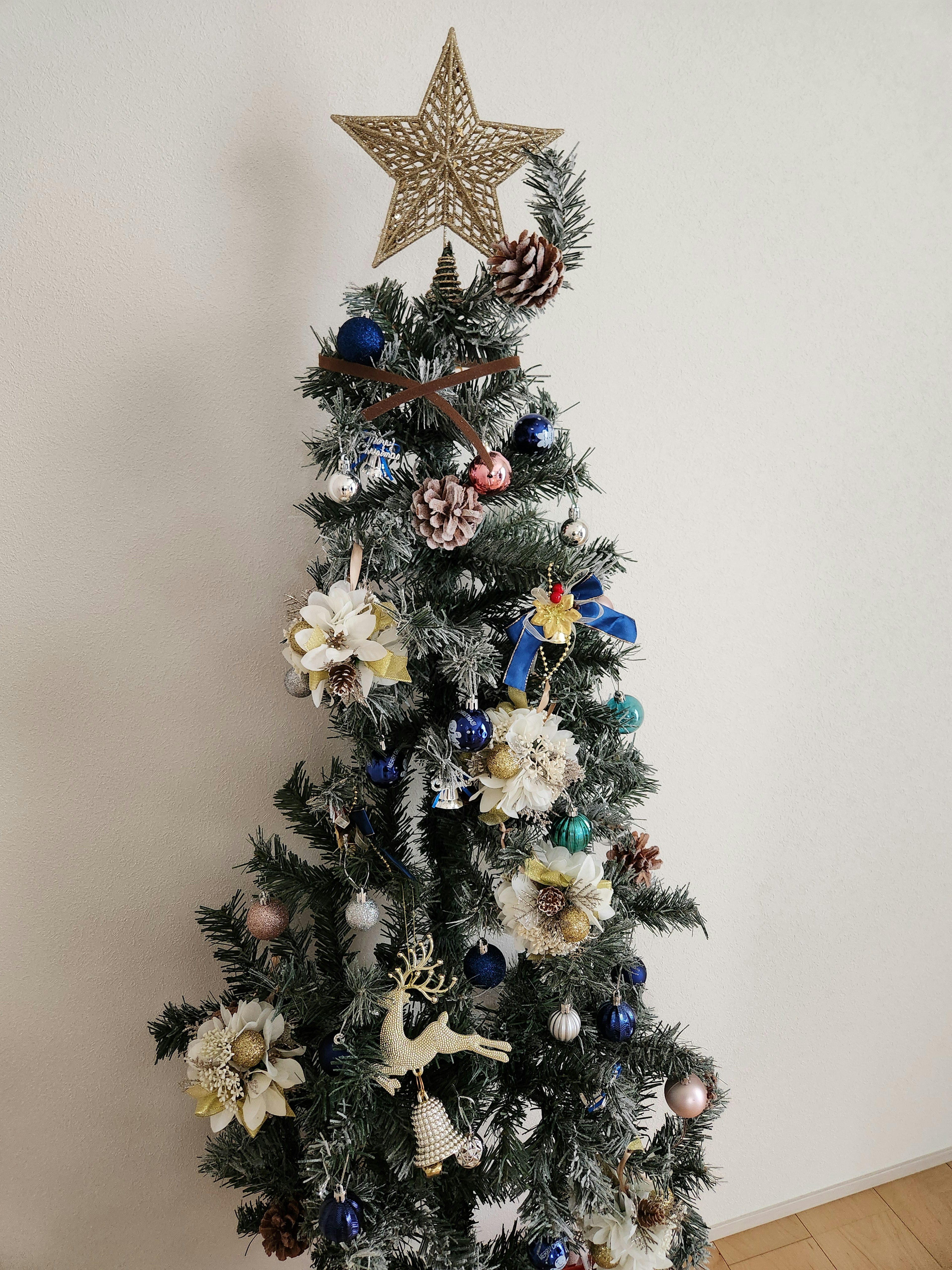 Árbol de Navidad blanco decorado con adornos coloridos y una estrella en la cima