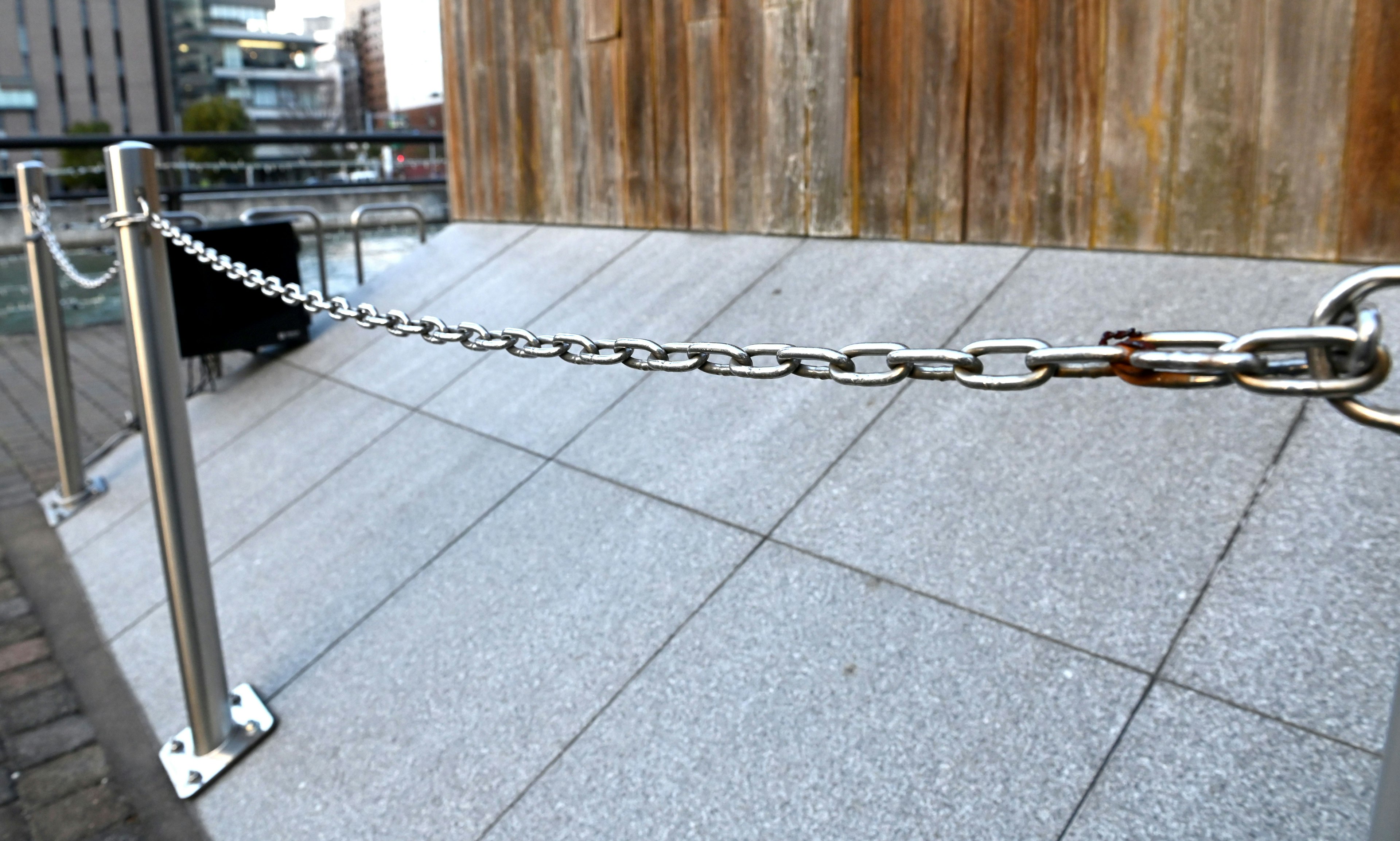 Metal chain surrounding granite floor with wooden wall