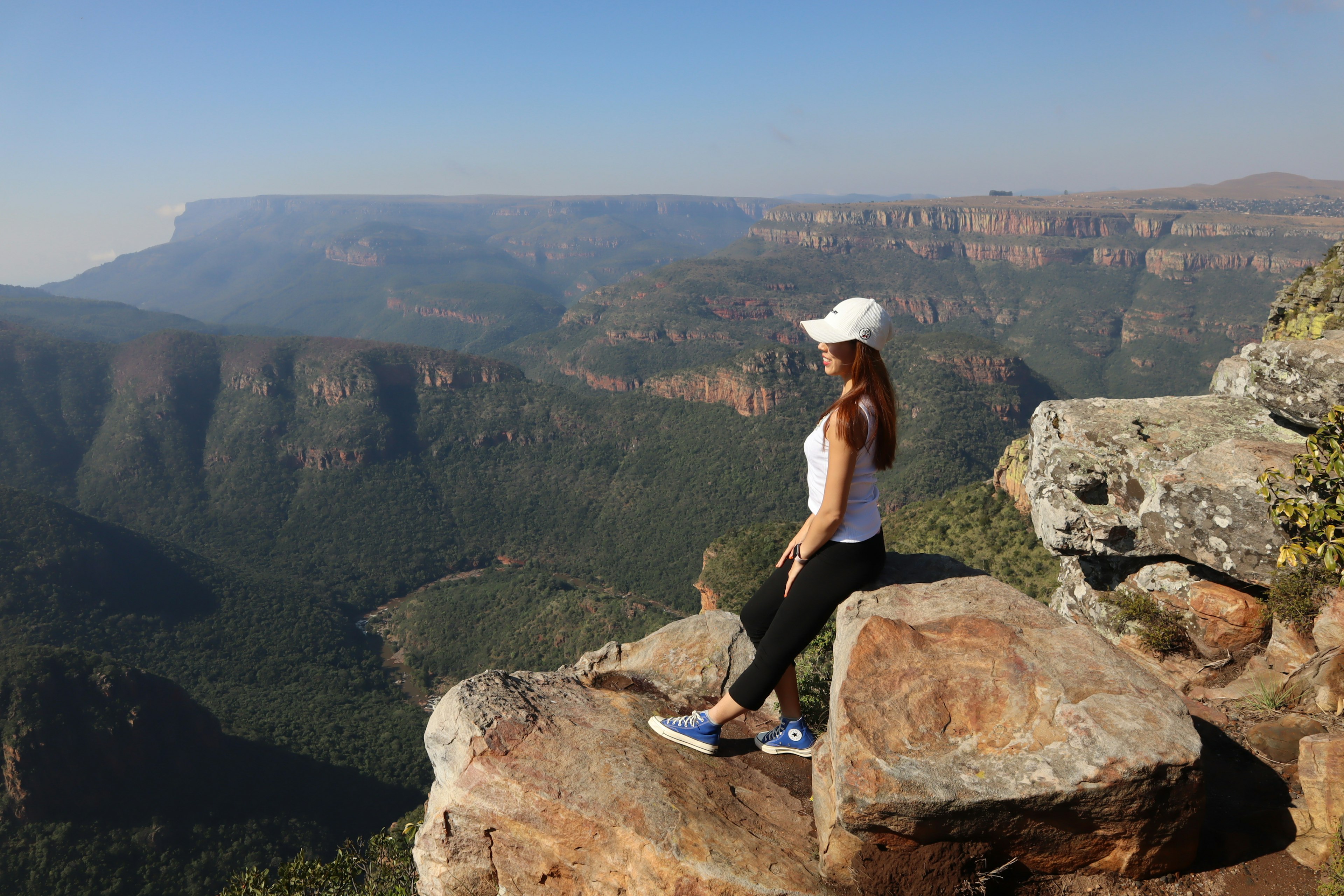 Mujer sentada en una roca con una impresionante vista de las montañas