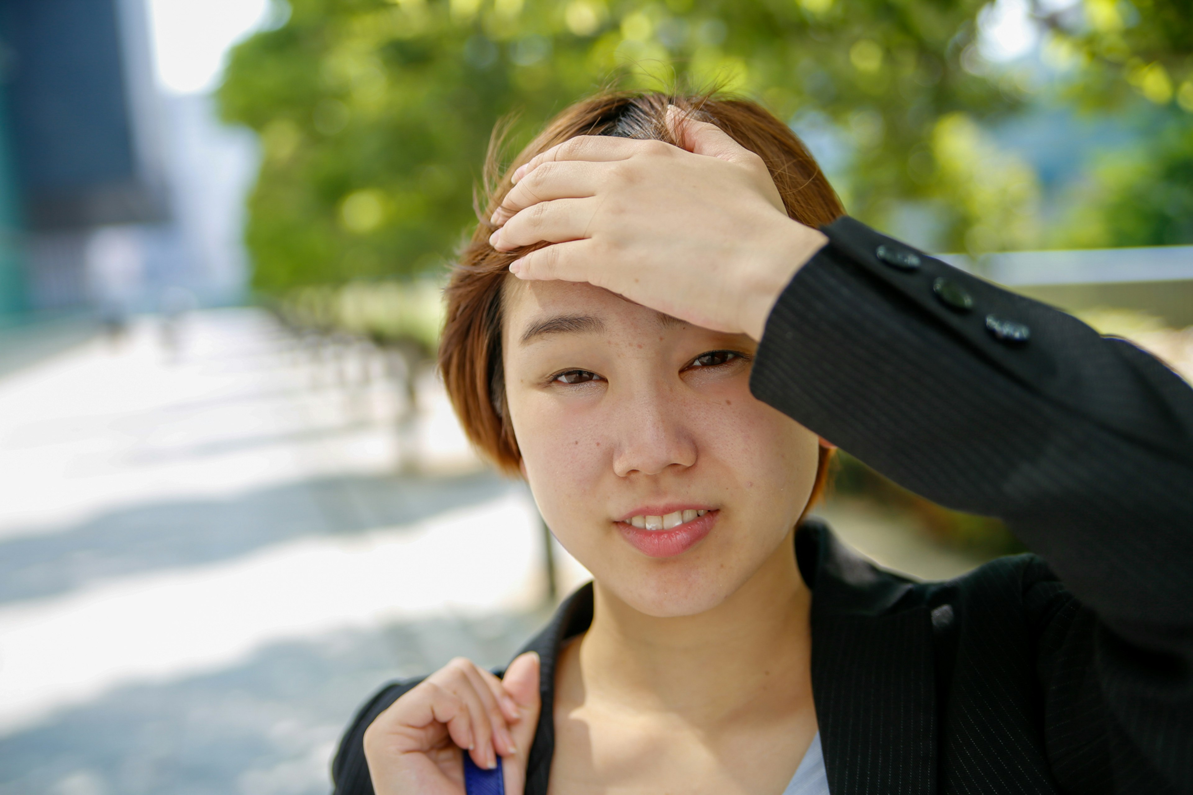 Woman smiling and touching her forehead in a business setting