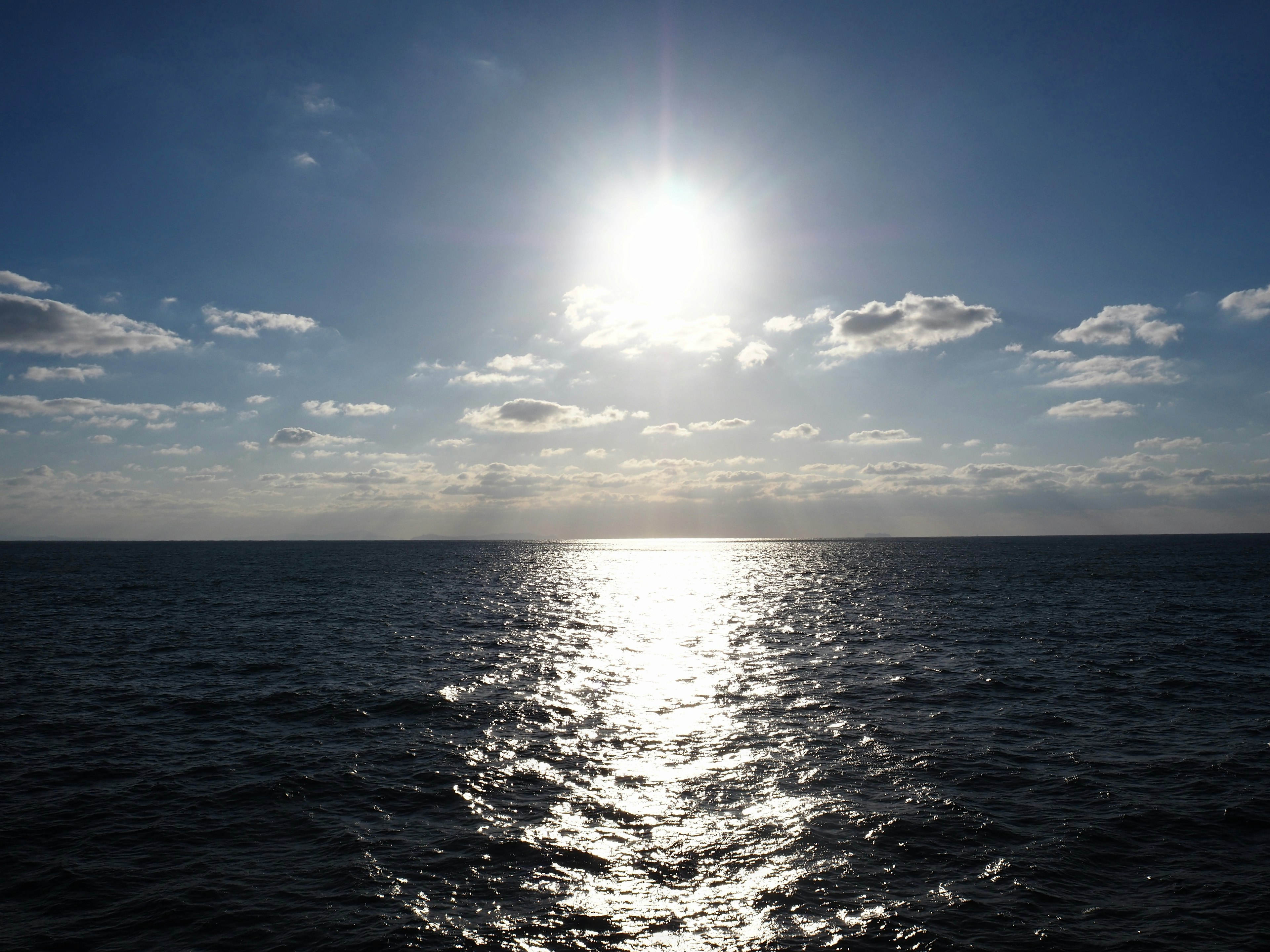 Un sol brillante que brilla sobre el océano con reflejos centelleantes en el agua