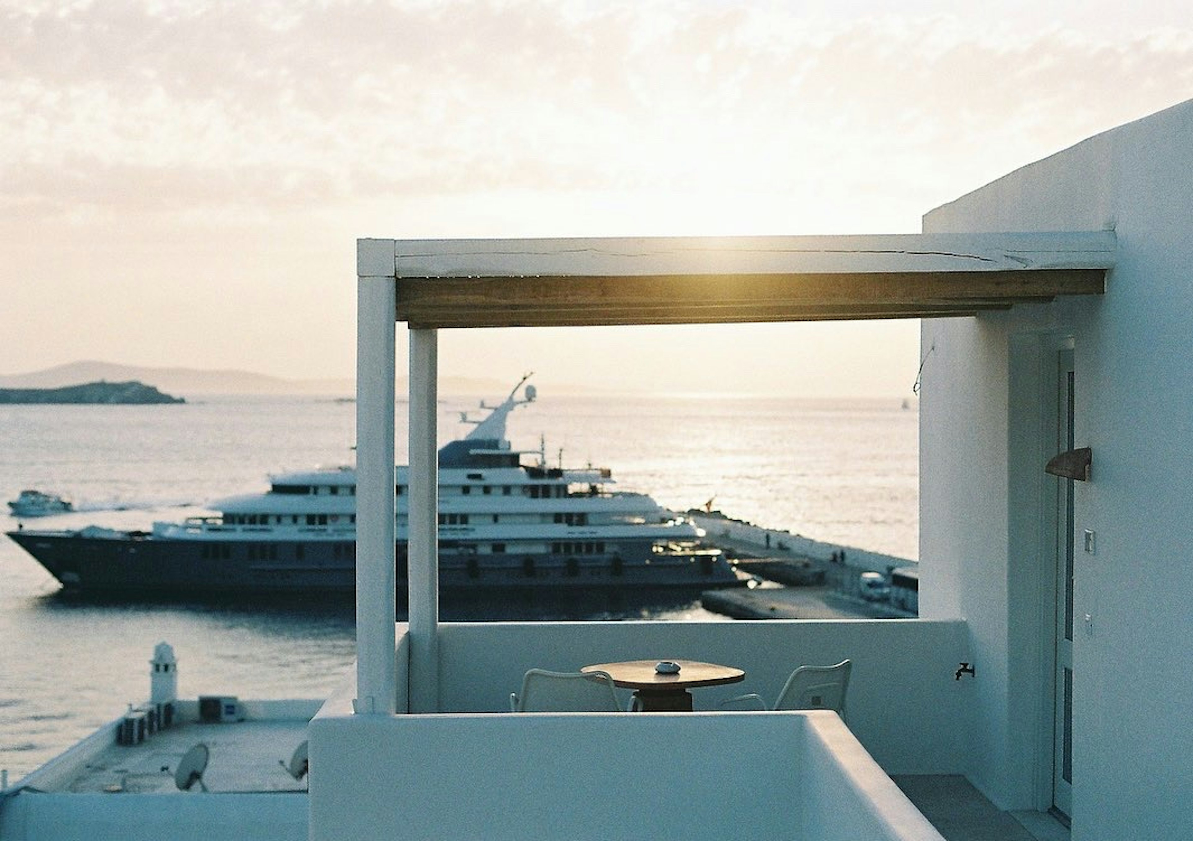 View of a luxurious yacht at sunset from a terrace overlooking the sea