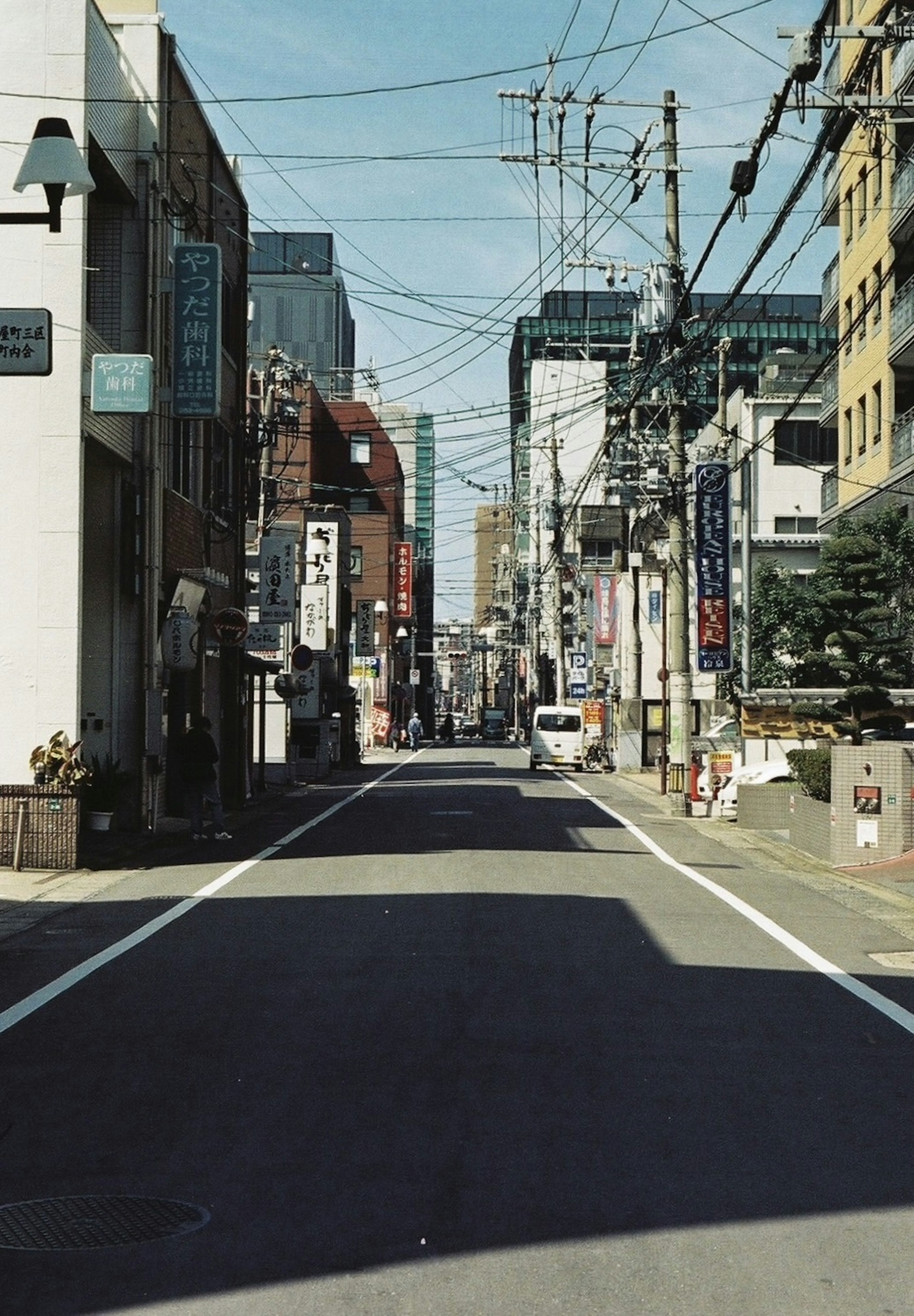 Quiet urban street lined with buildings and power lines