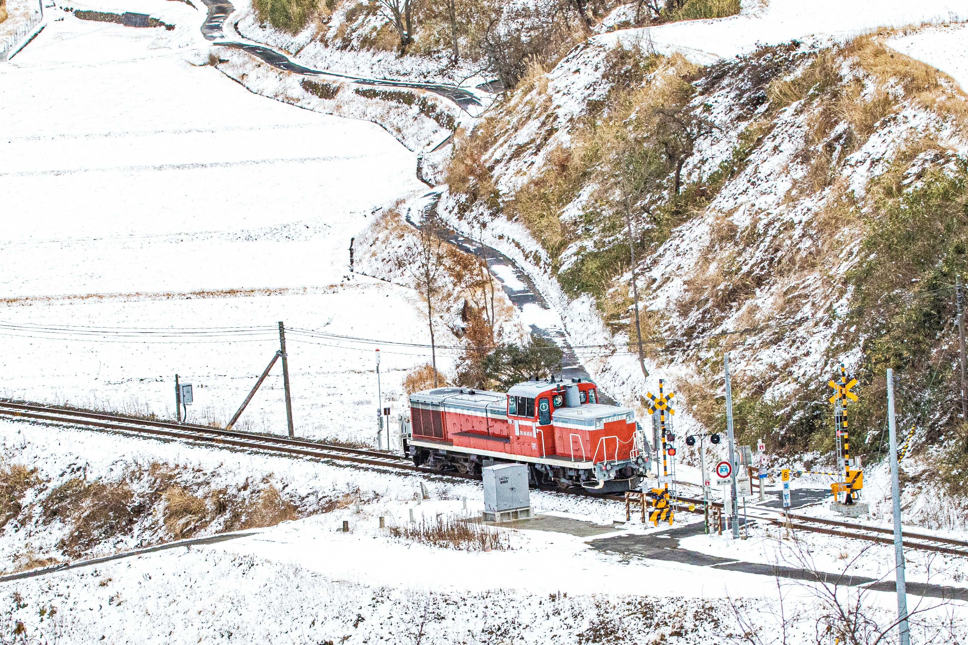 Rote Lokomotive, die durch eine verschneite Landschaft fährt