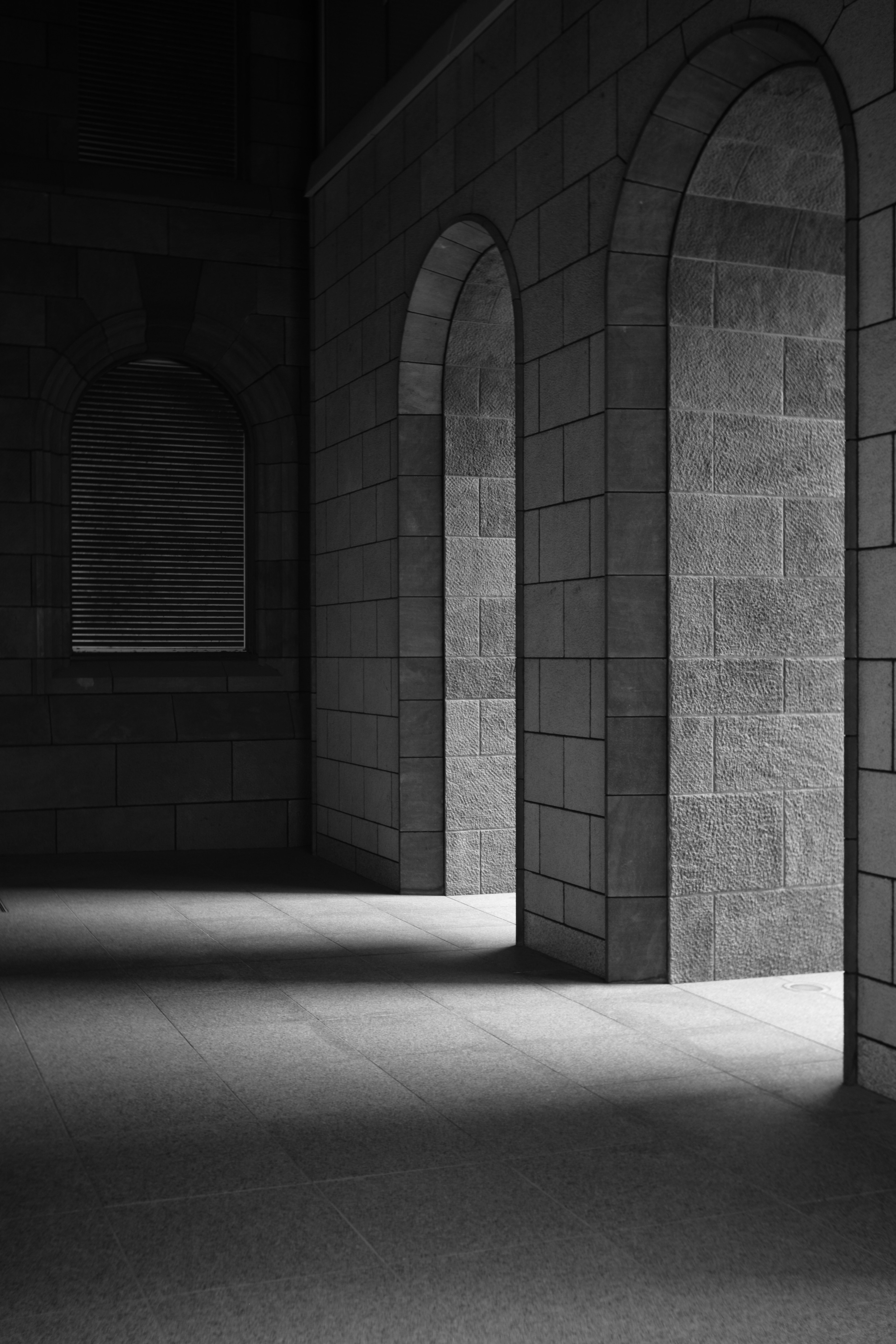 Stone building with arched doorways in a dark space