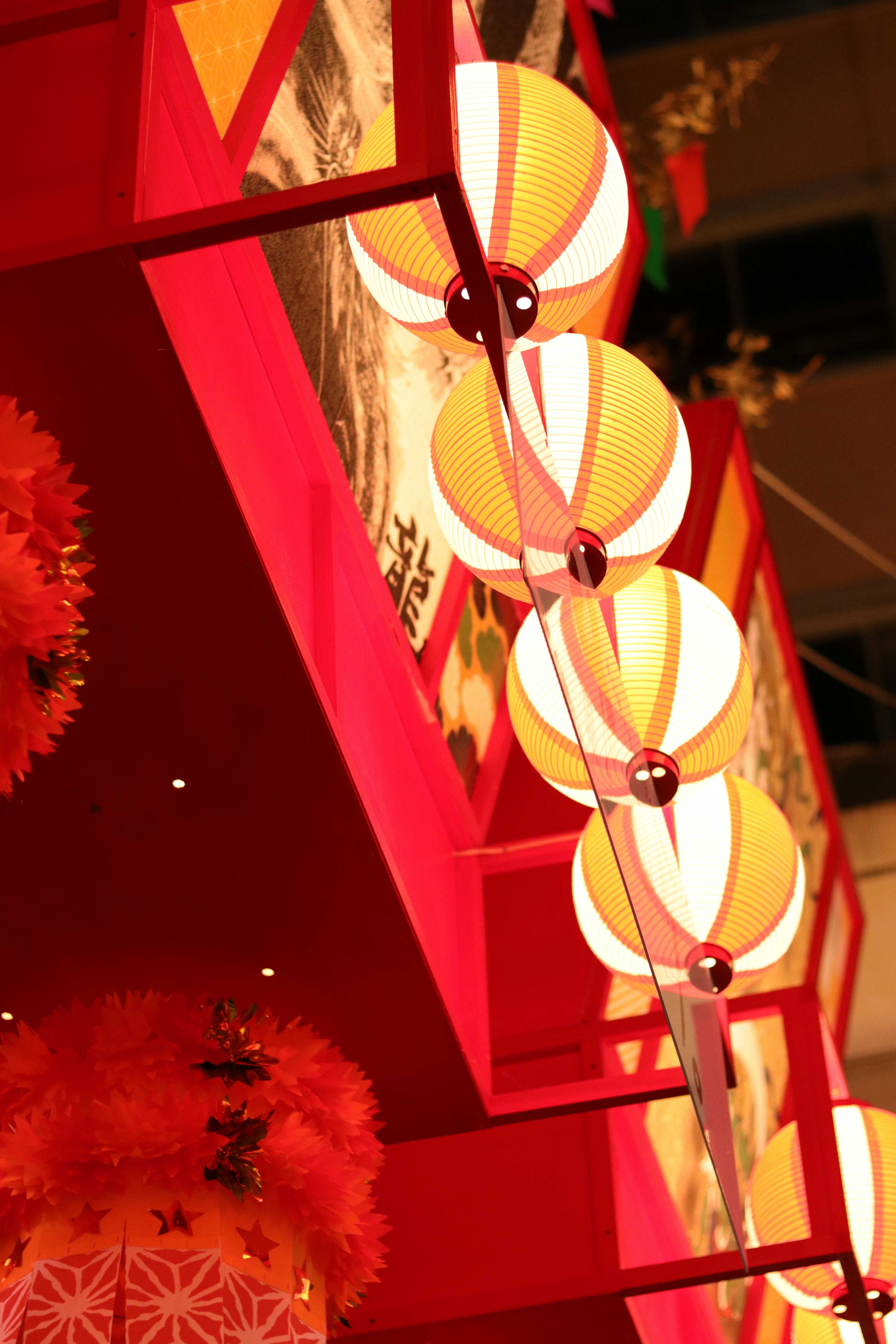 Vibrant red background with orange and white lanterns arranged decoratively