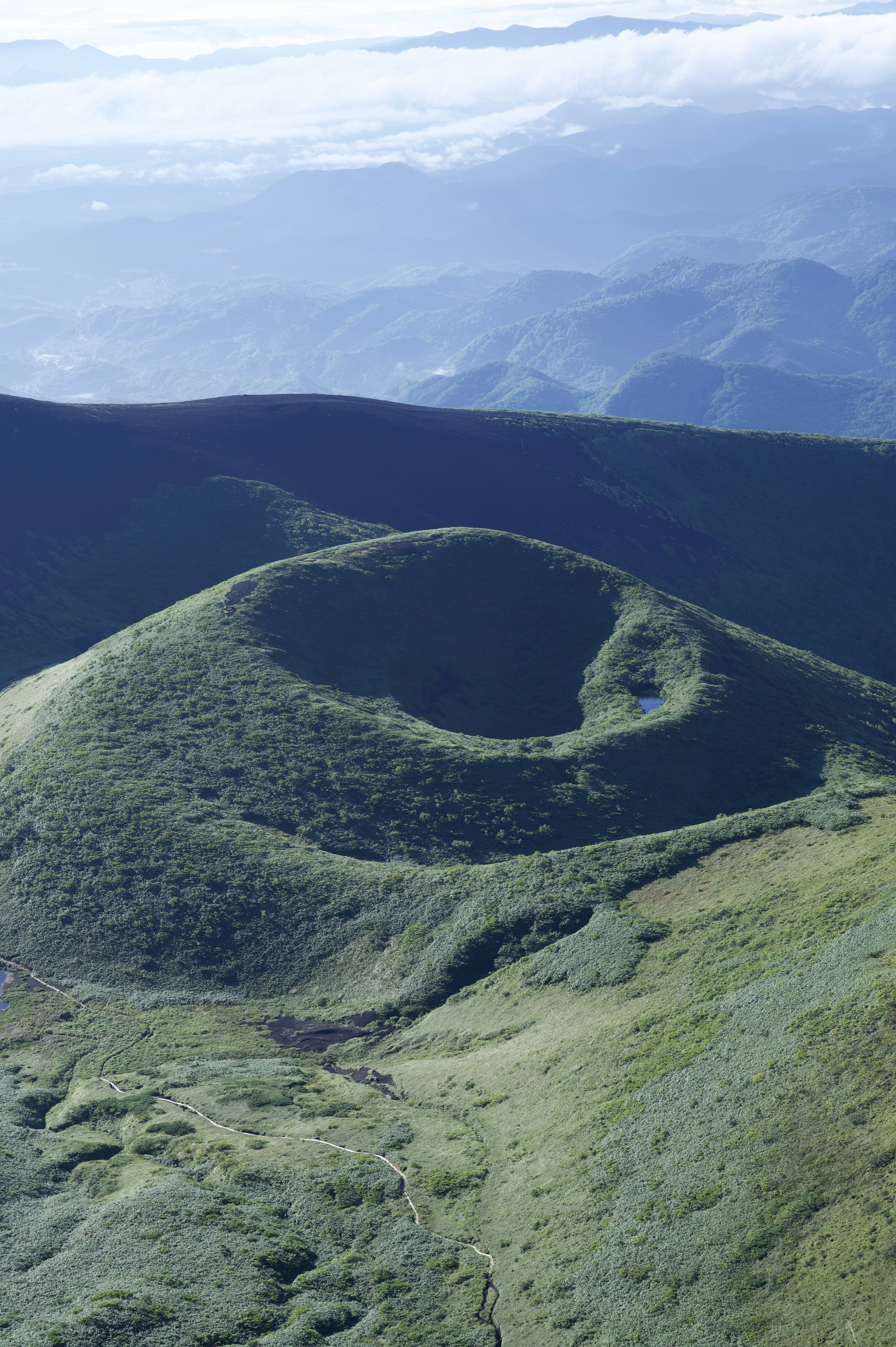 Landscape of green hills with a volcanic crater