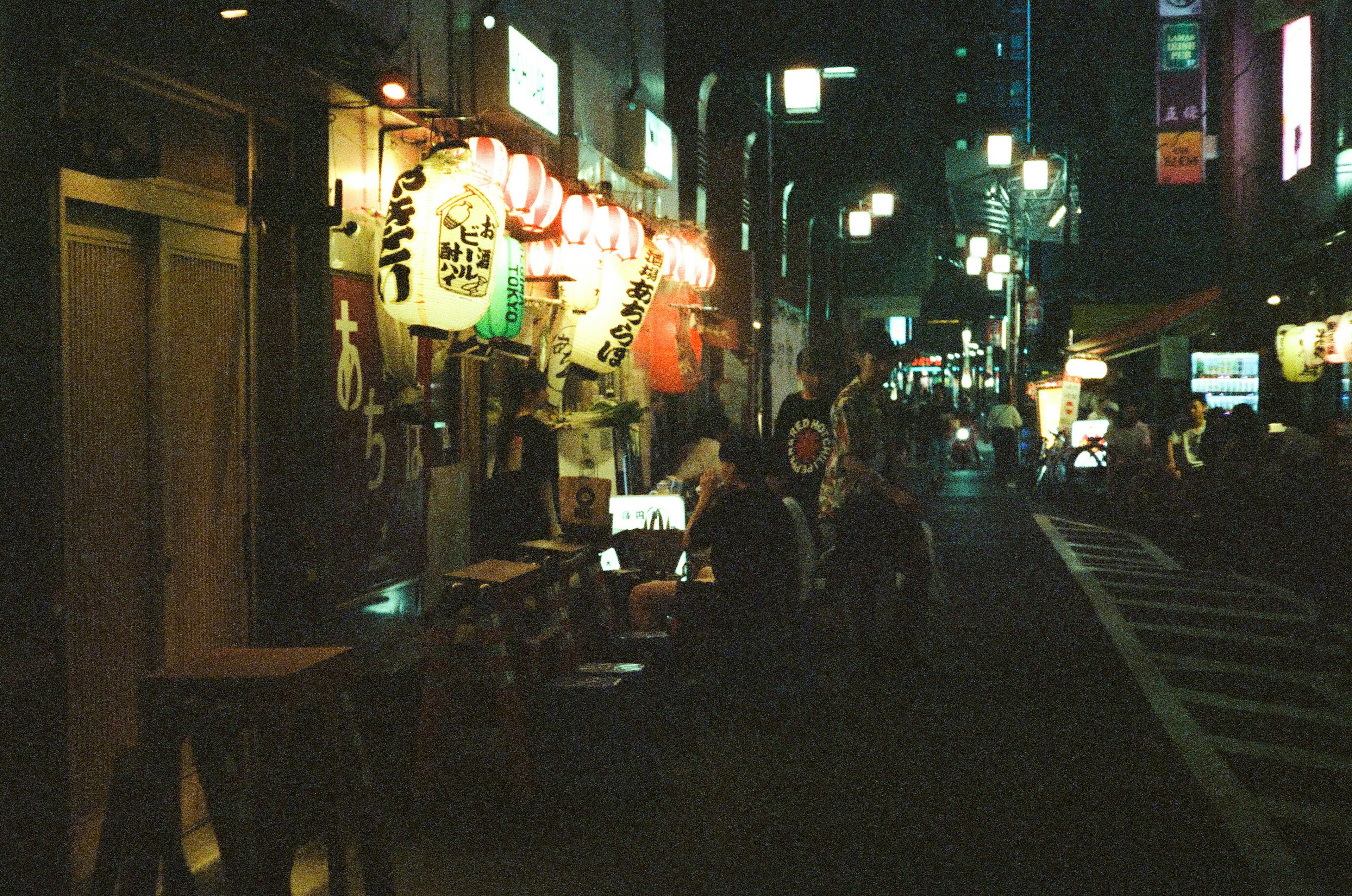 夜の街に浮かぶ提灯と人々の姿