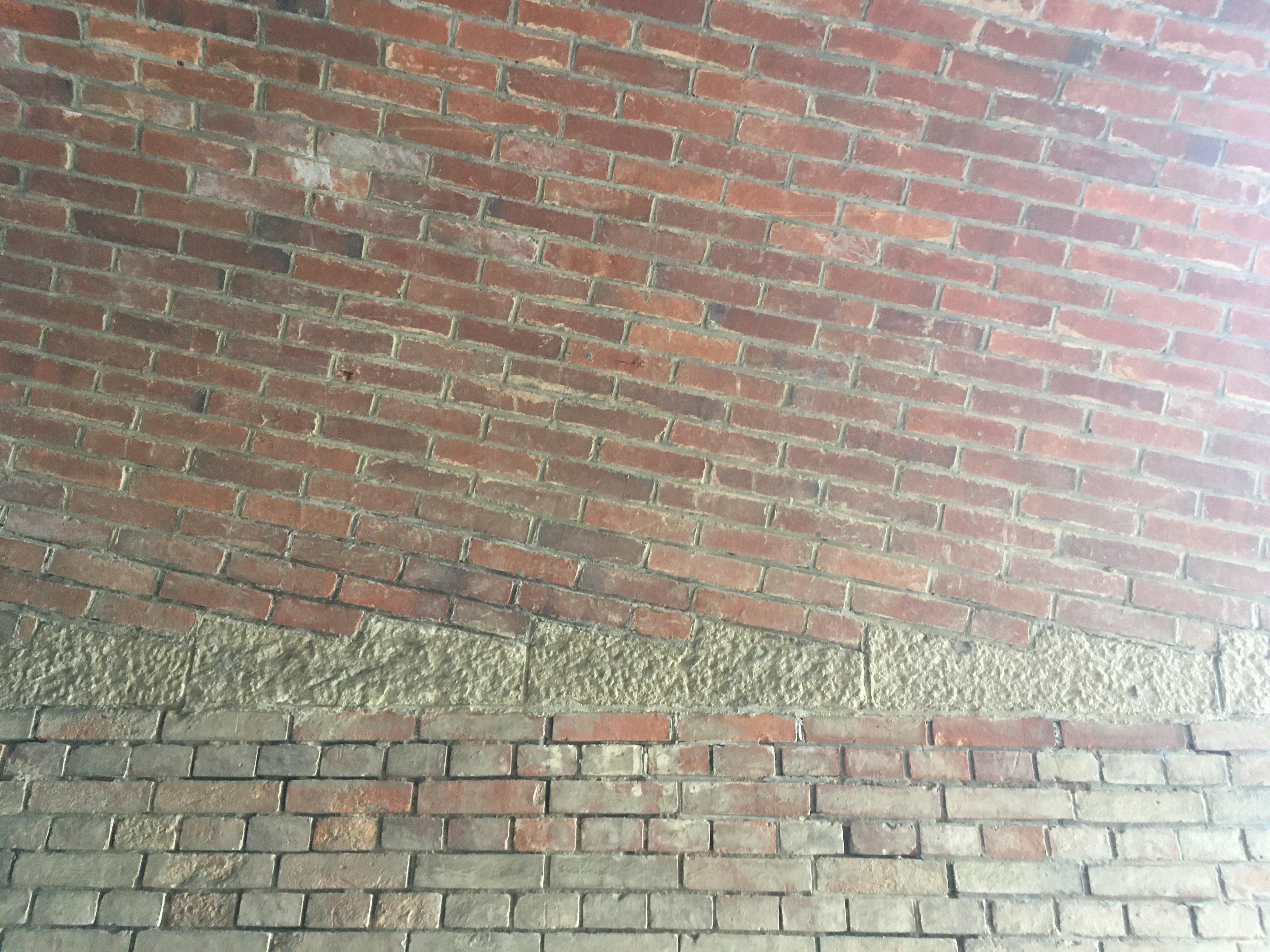 Textured wall featuring red bricks and concrete