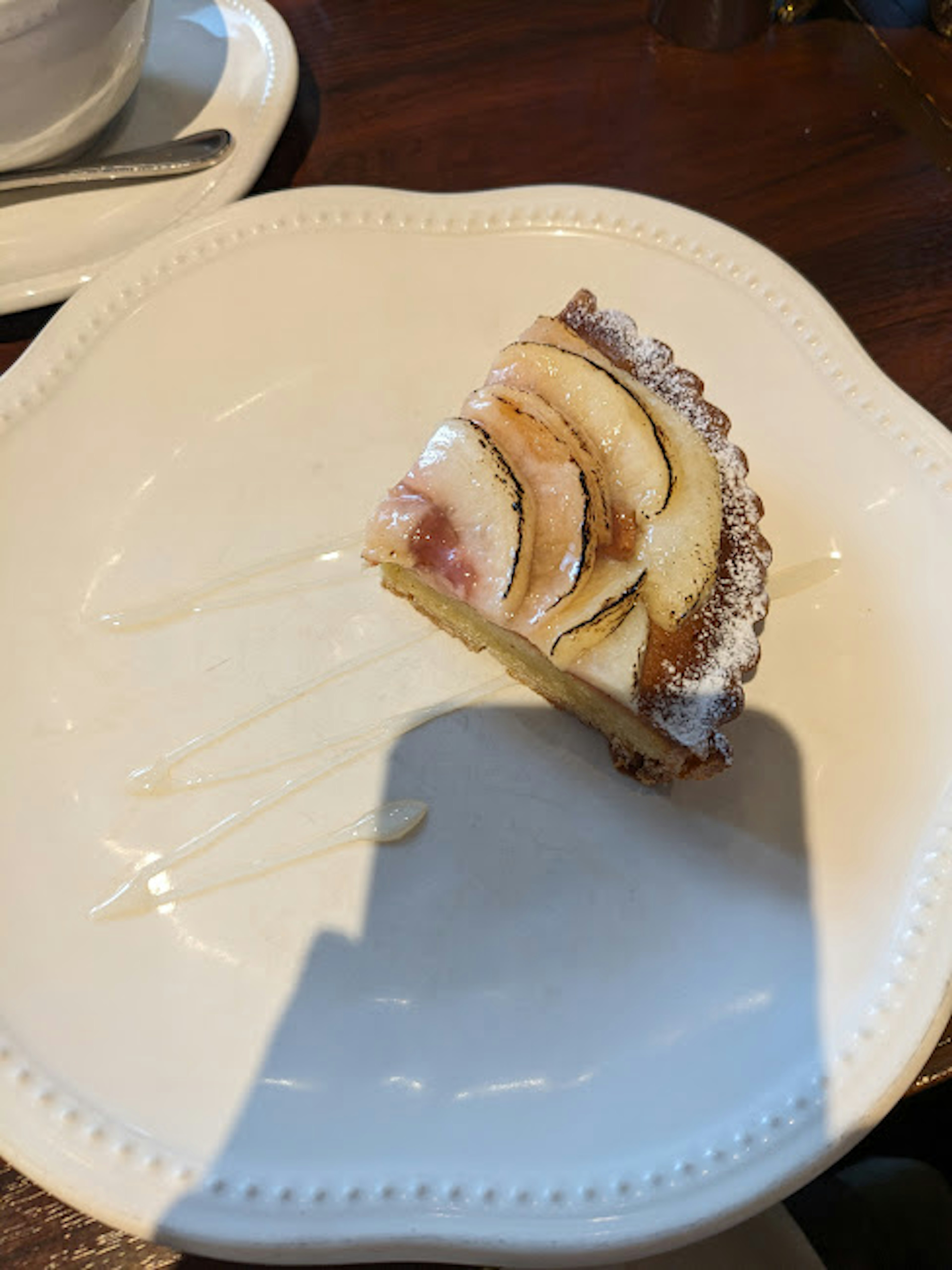 Une tranche de gâteau garnie de tranches de banane sur une assiette blanche