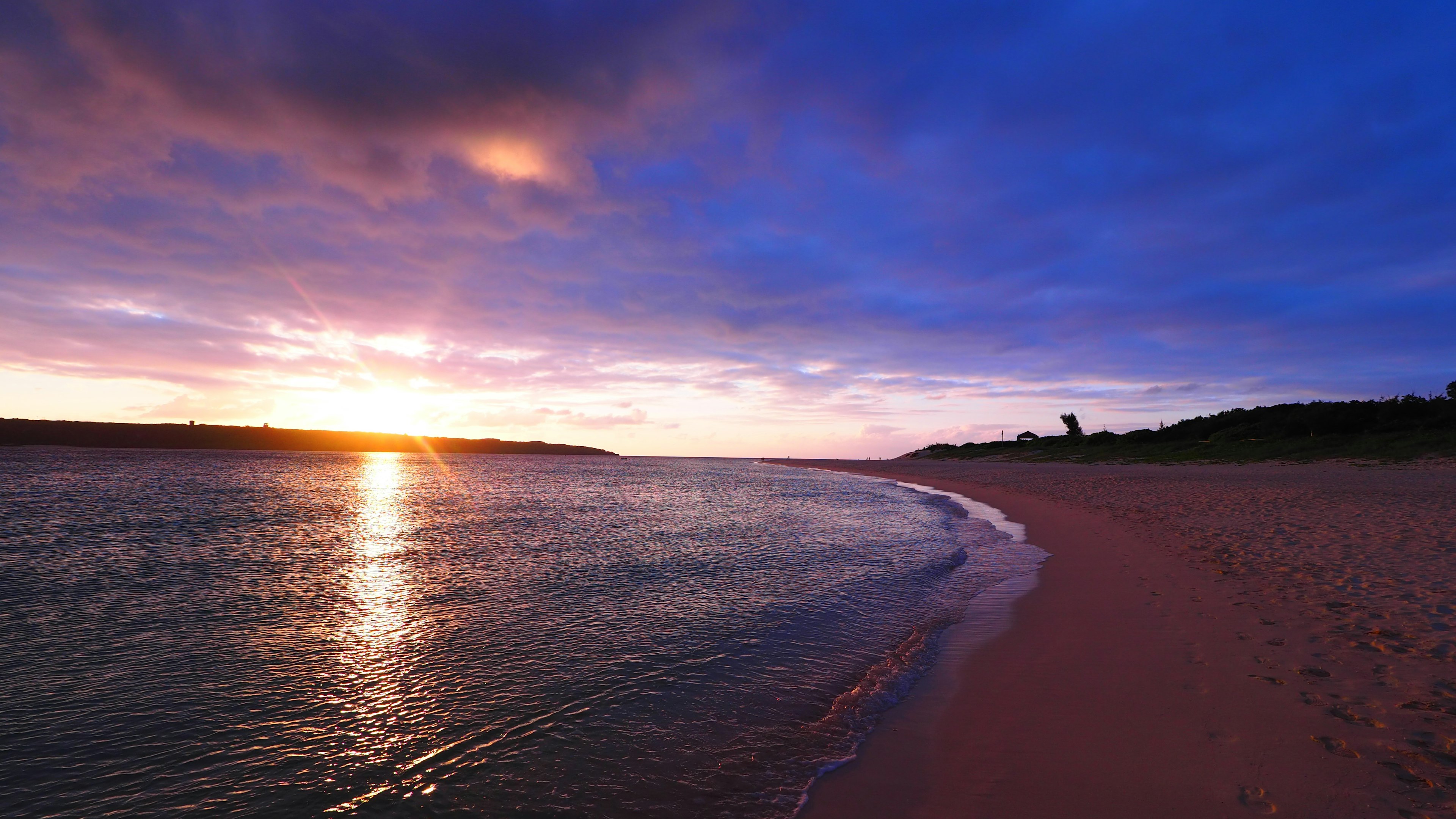 Hermoso paisaje de playa con el atardecer reflejándose en el agua