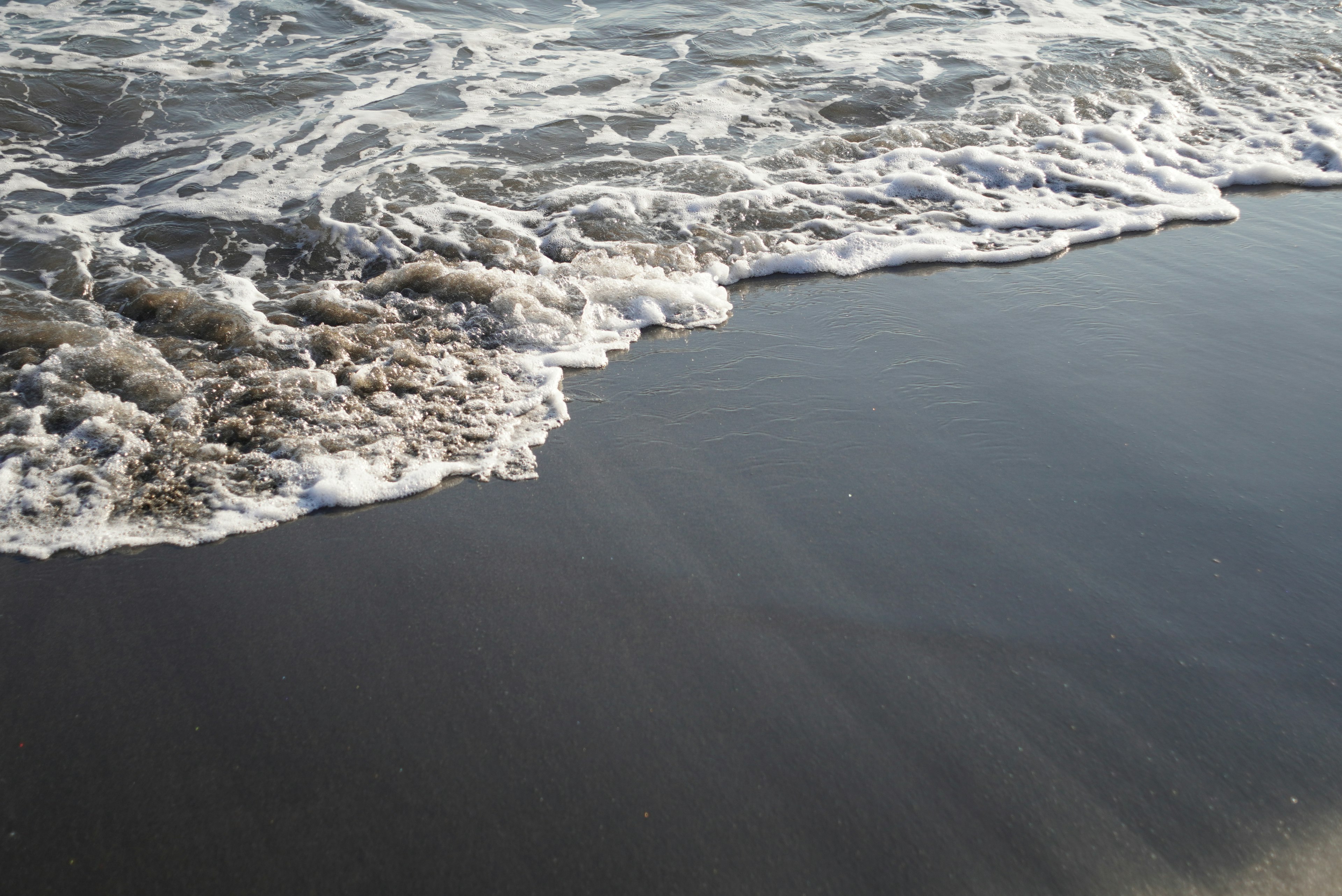 海の波が砂浜に打ち寄せる様子