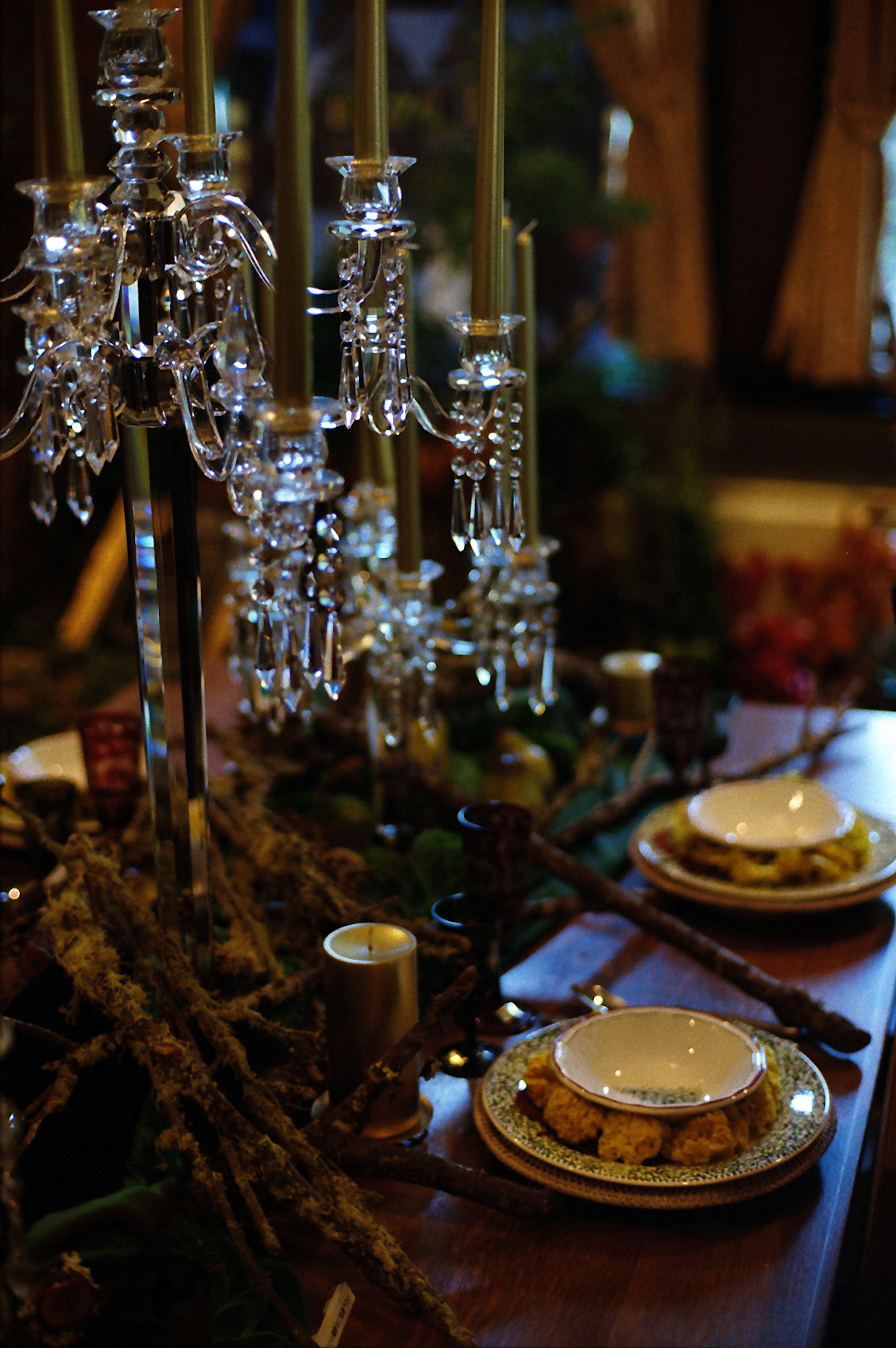 Mesa elegante con candelabros de cristal y platos decorativos