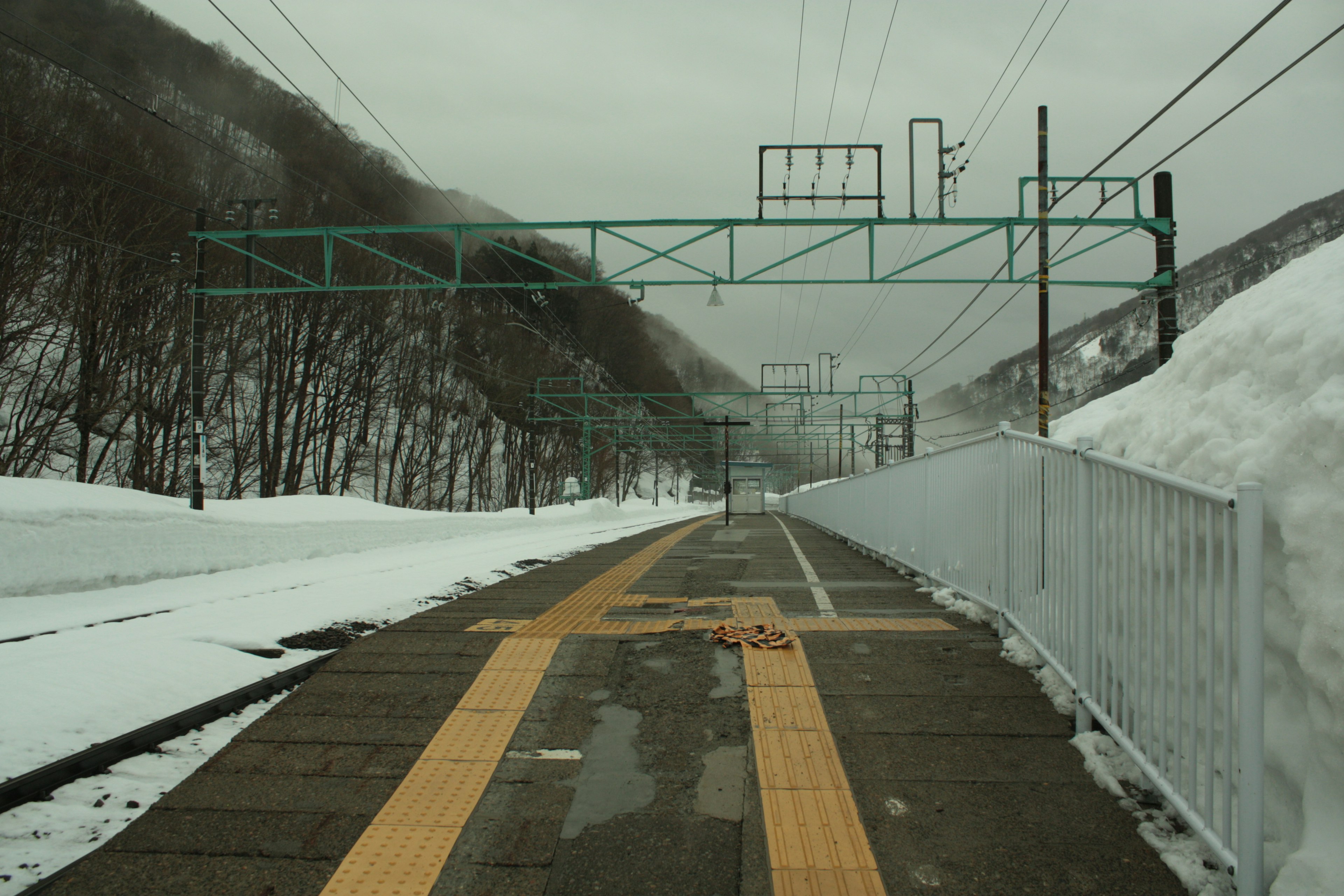 Snow-covered train platform with mountains in the background