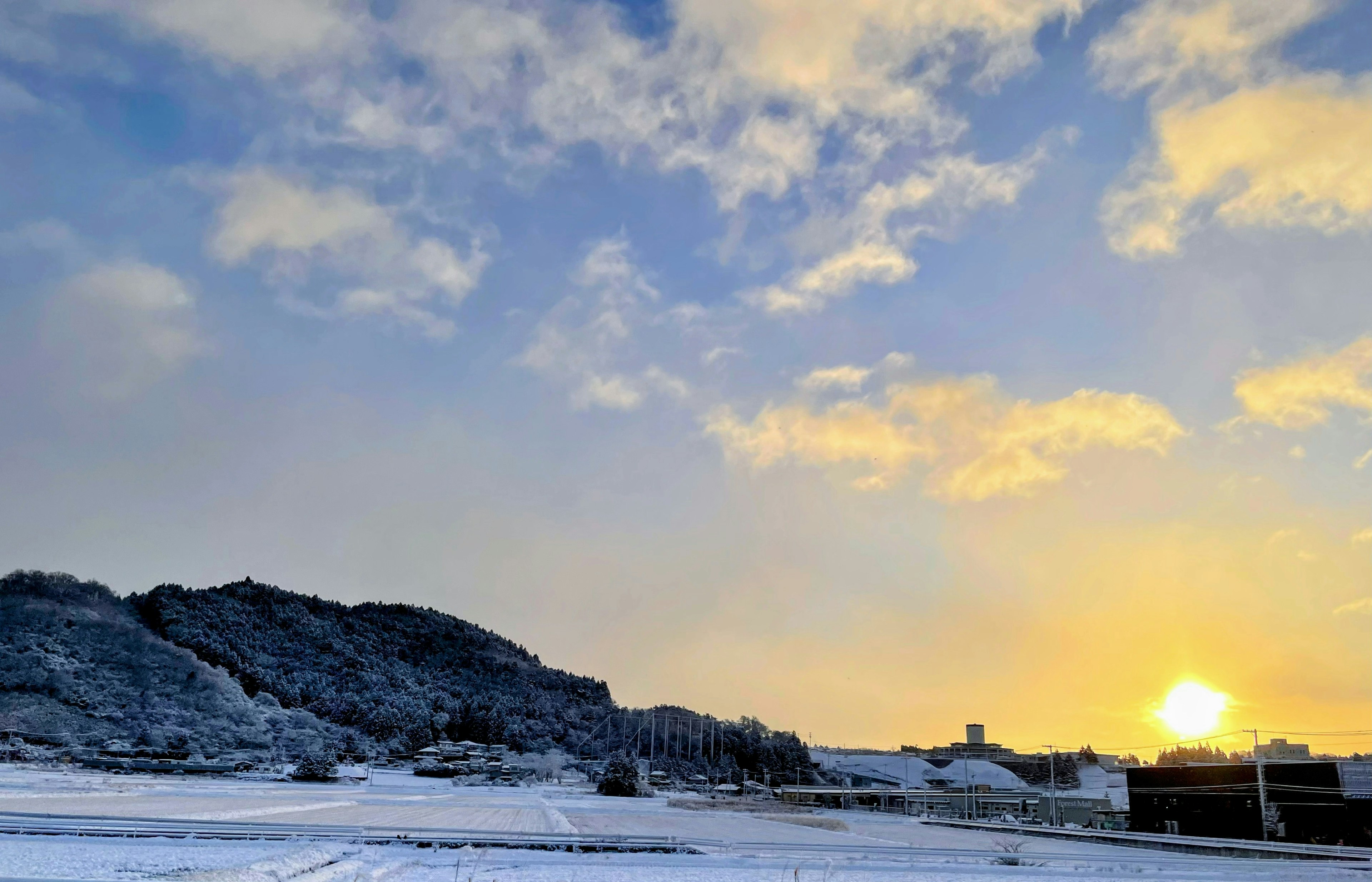 Paesaggio innevato con cielo blu nuvoloso e alba