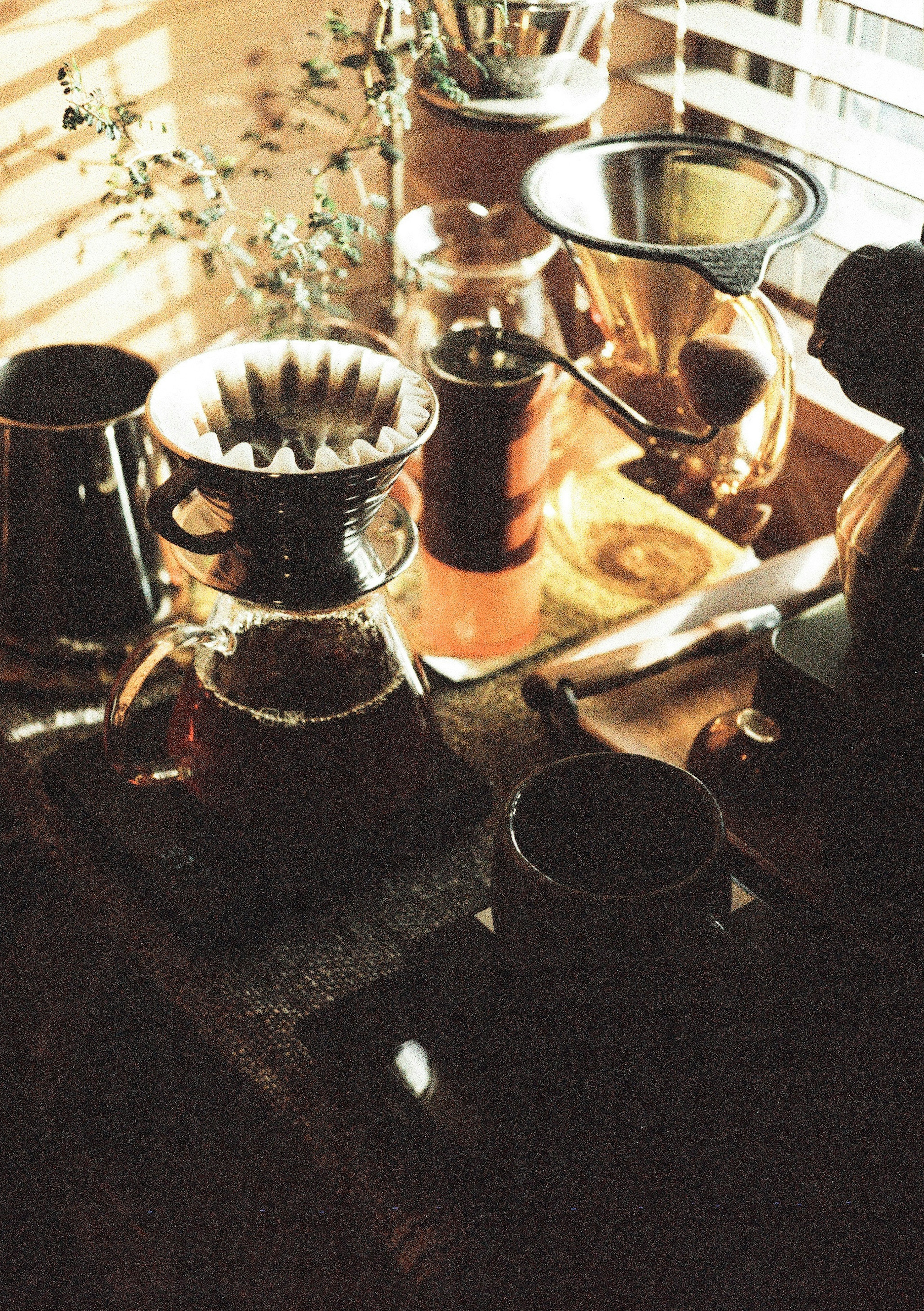 A table with coffee brewing equipment illuminated by natural light