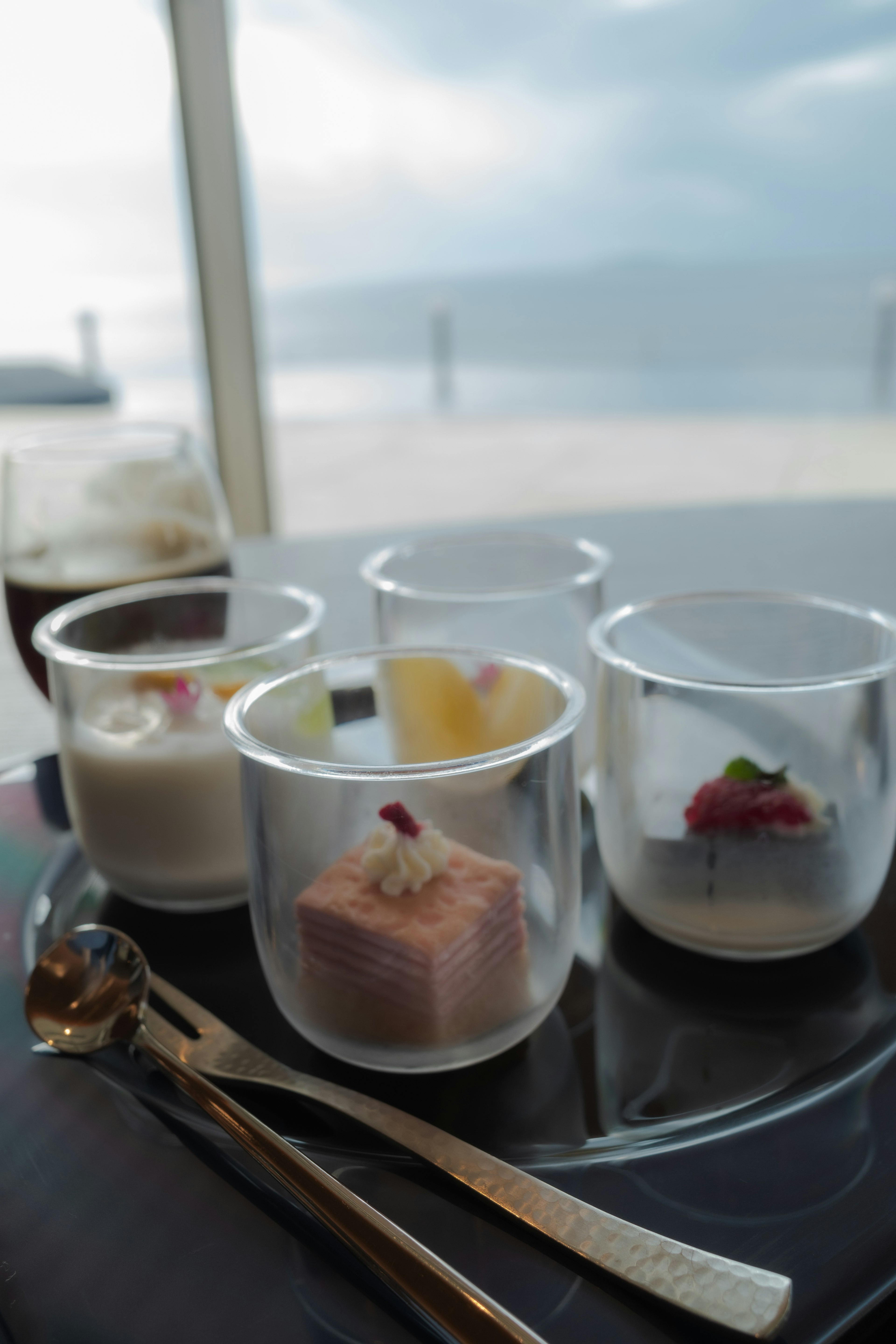 An elegant dessert assortment in clear cups with a scenic background