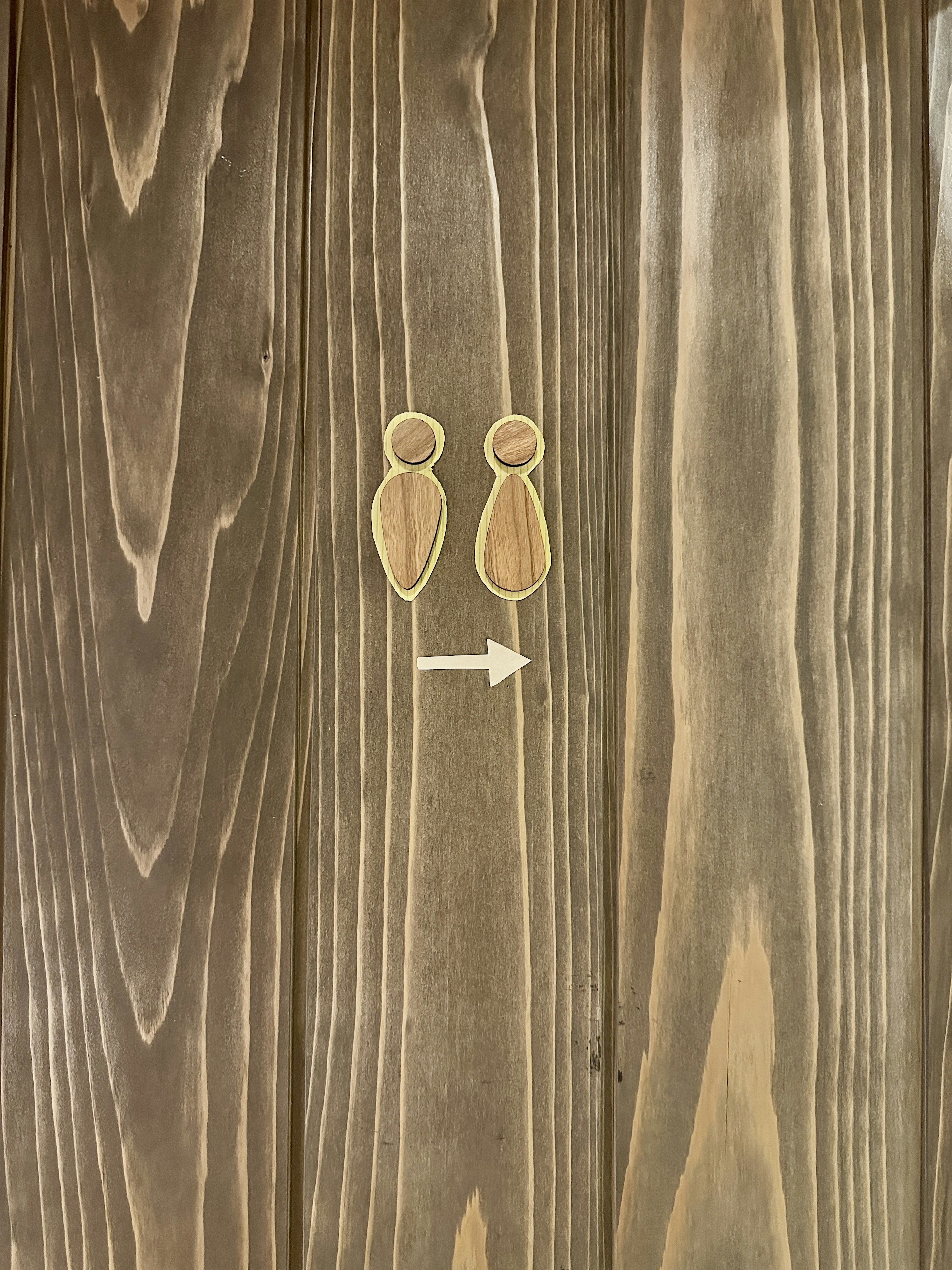 An image featuring two silhouette figures against a wood grain background