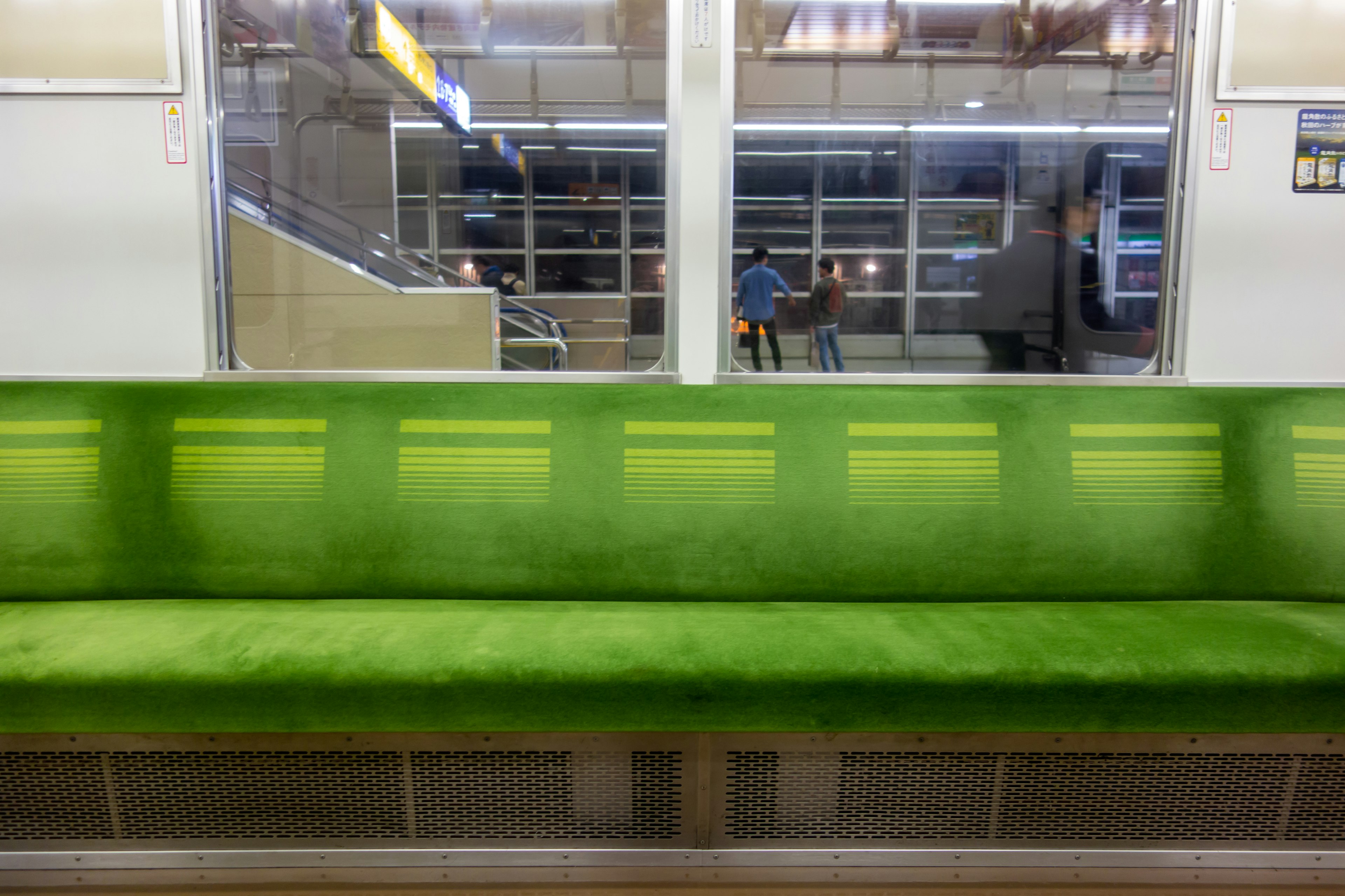 Innenraum eines U-Bahn-Zugs mit einem grünen Sofa