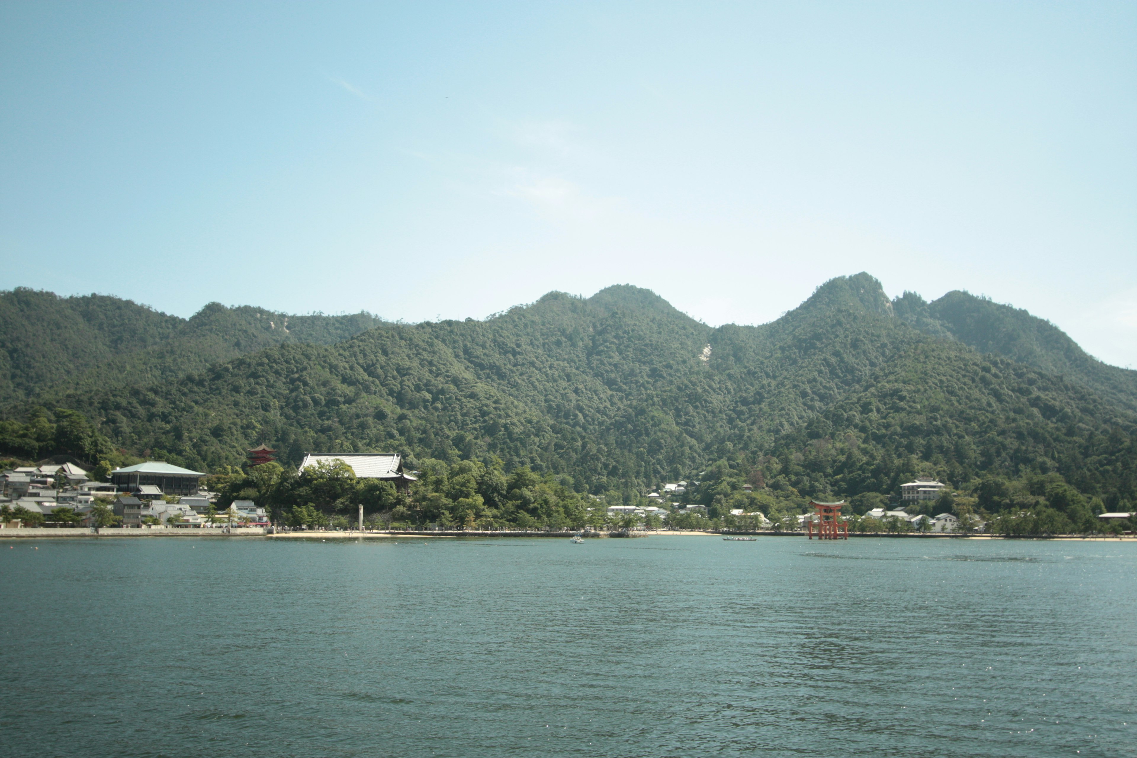 海邊寧靜村莊與郁郁蔥蔥的山脈的風景