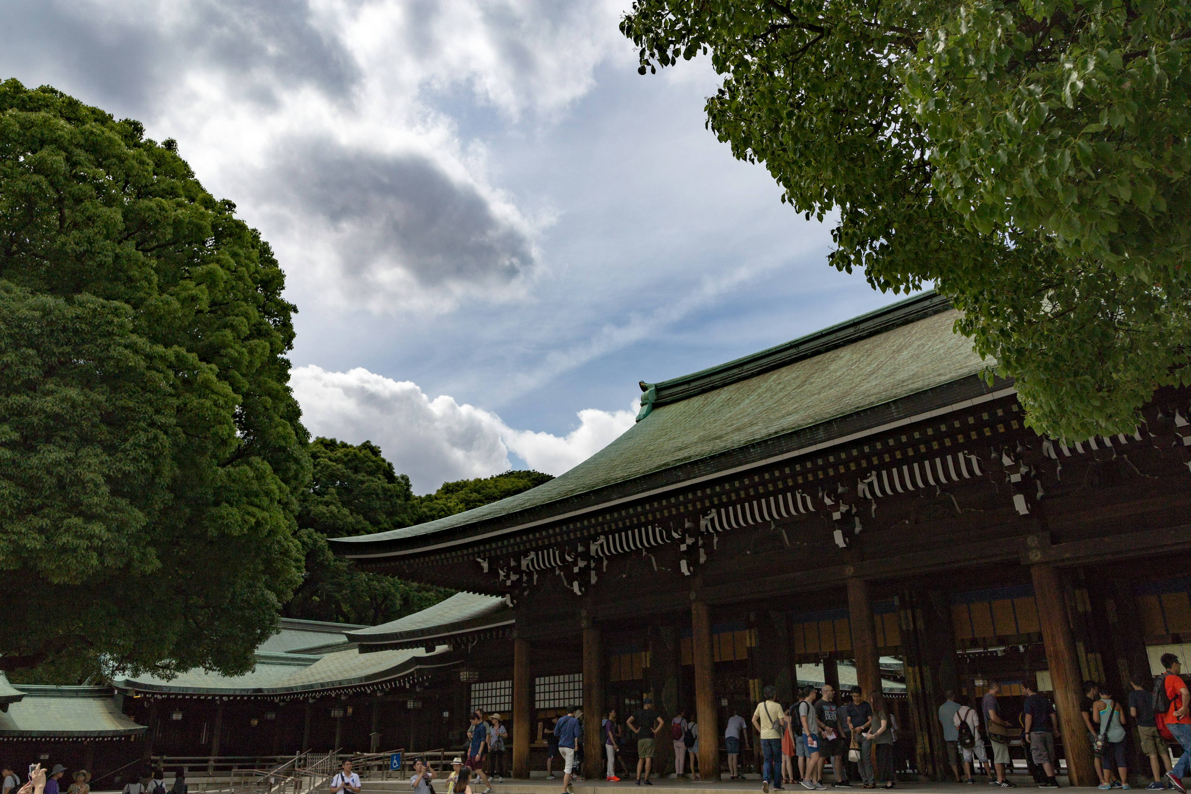 Shrine building with lush green trees and blue sky