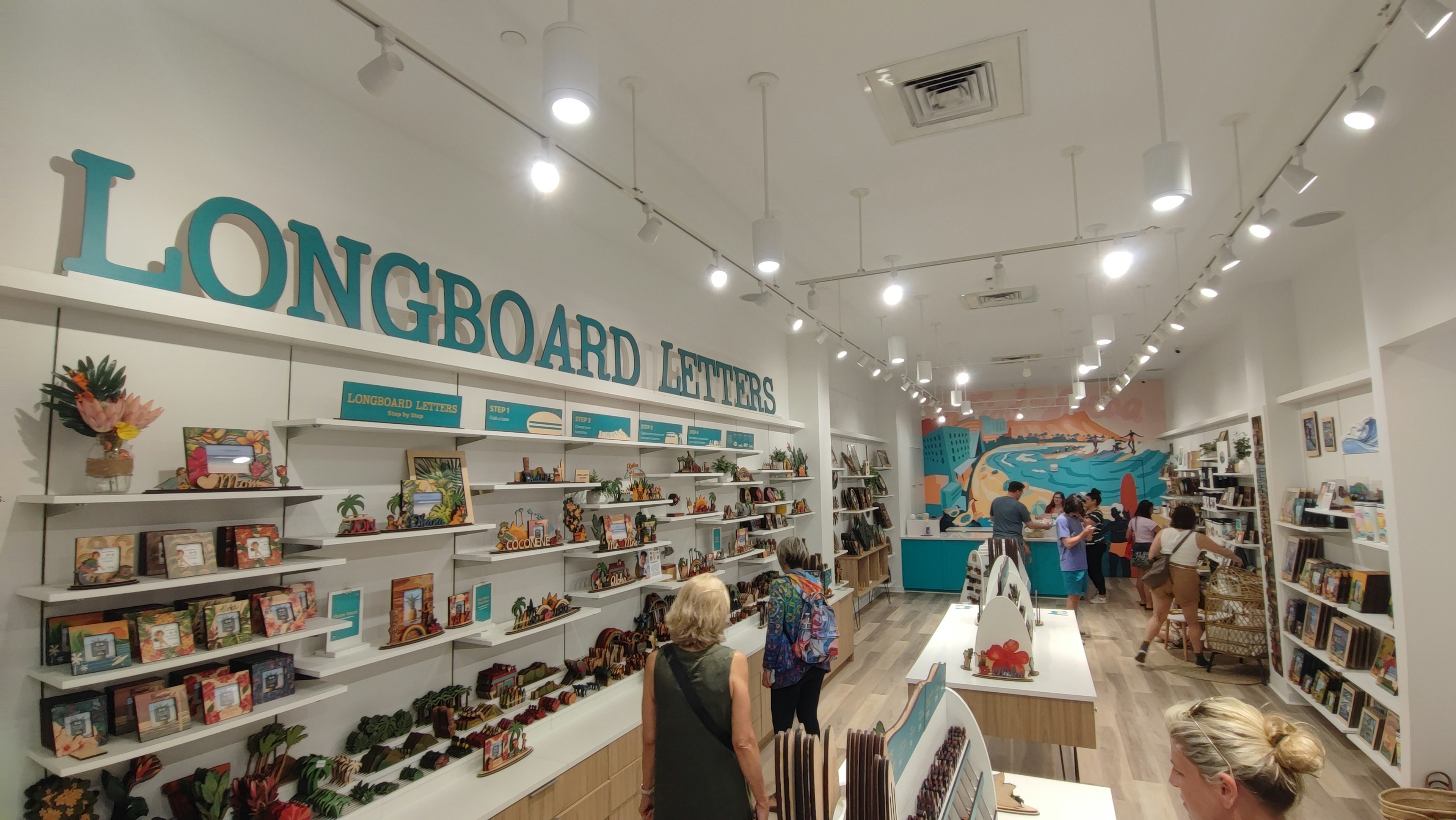 ภายในร้านขาย longboard ที่สว่างสดใสพร้อมการจัดแสดงสีสันสดใสและชั้นวาง