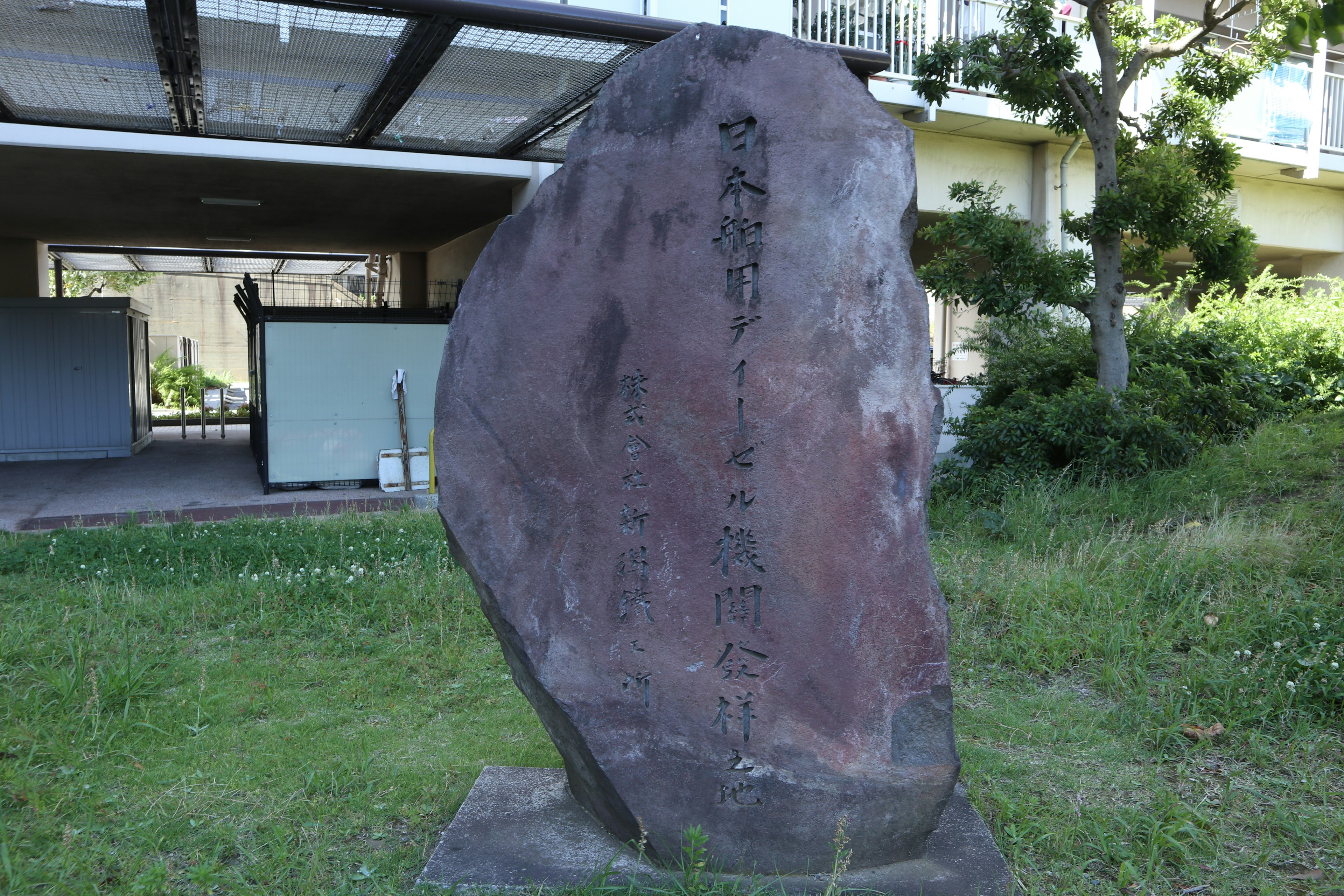 Large stone monument in a park with engraved text