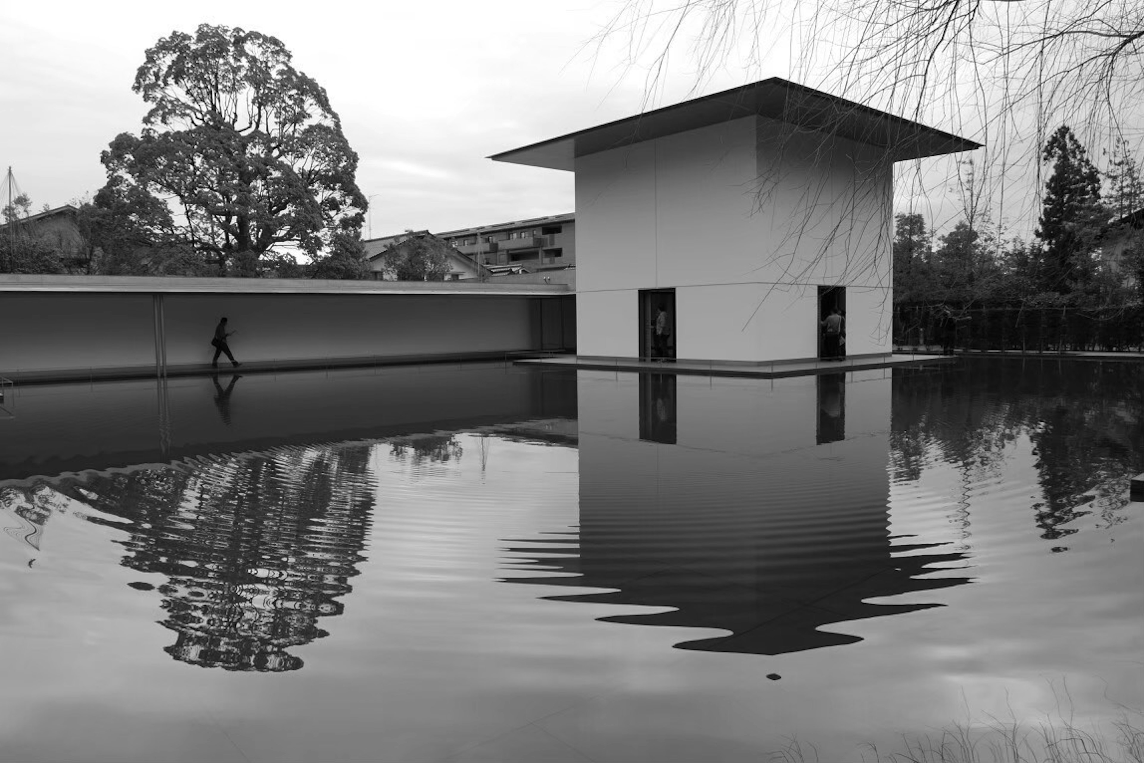 Eine ruhige Landschaft mit einem weißen Gebäude, das sich auf der Wasseroberfläche spiegelt