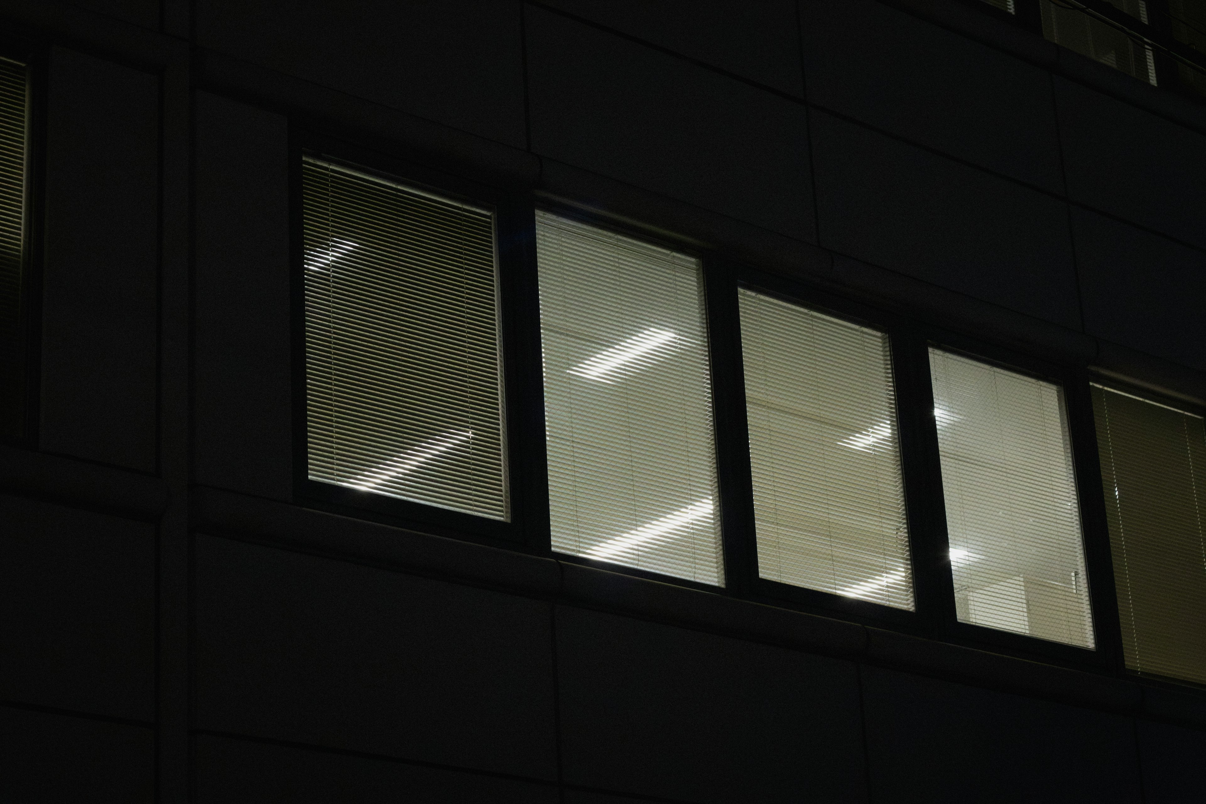 A scene featuring bright office windows against a dark background