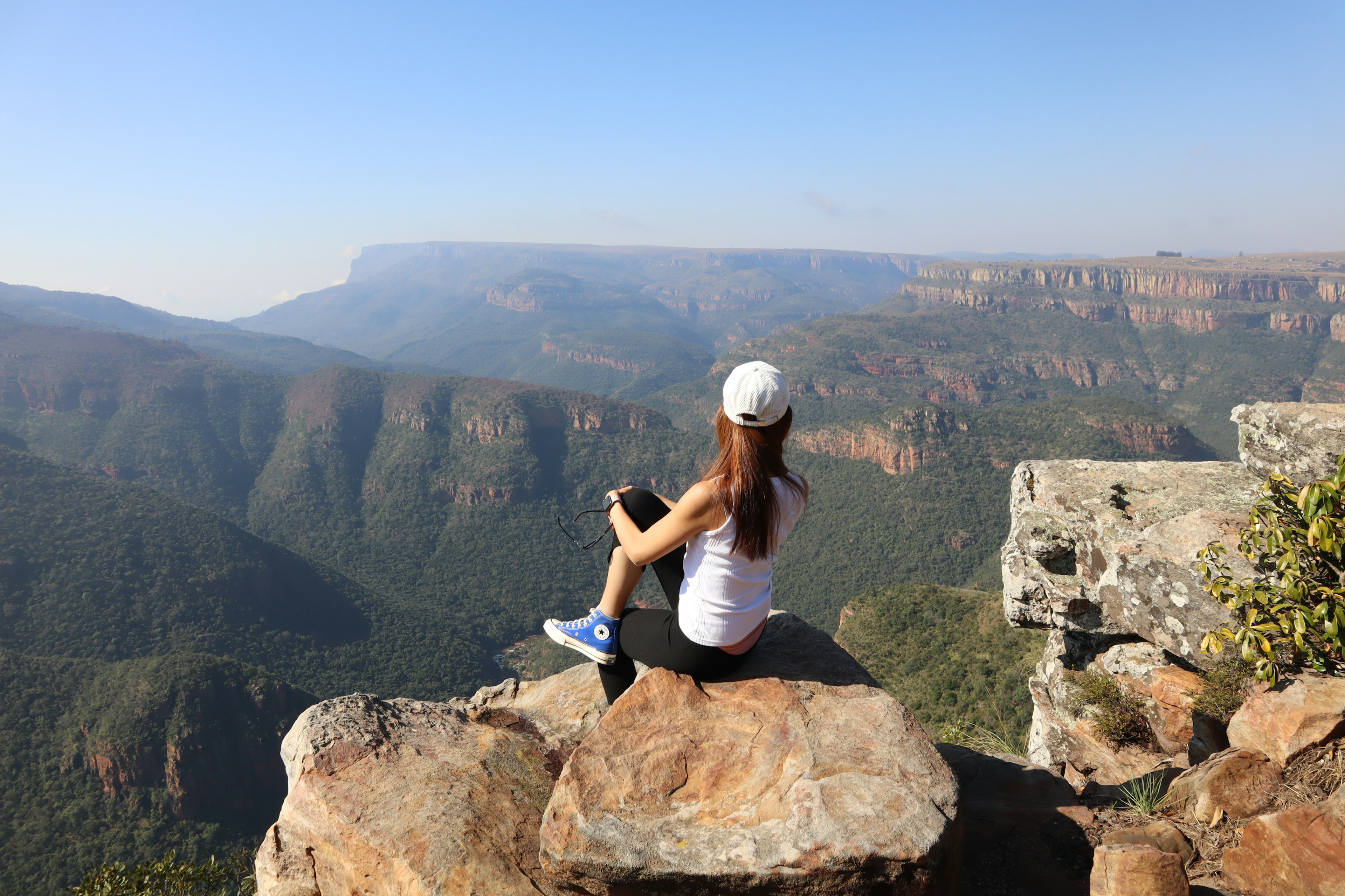 Femme assise sur une pierre avec une vue magnifique sur la montagne