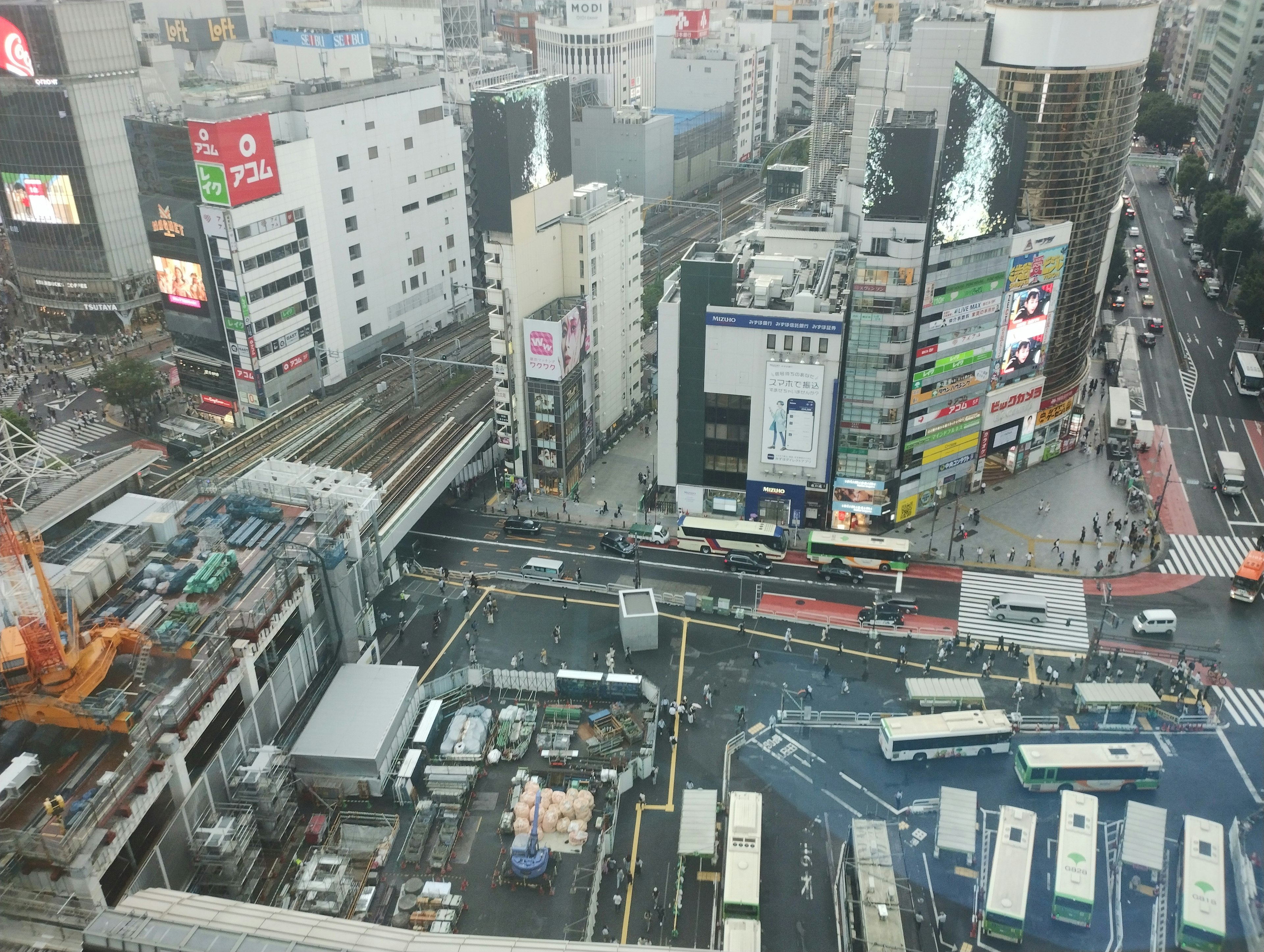 Pemandangan udara Shibuya dengan jalan-jalan ramai dan bangunan yang menunjukkan kehidupan perkotaan