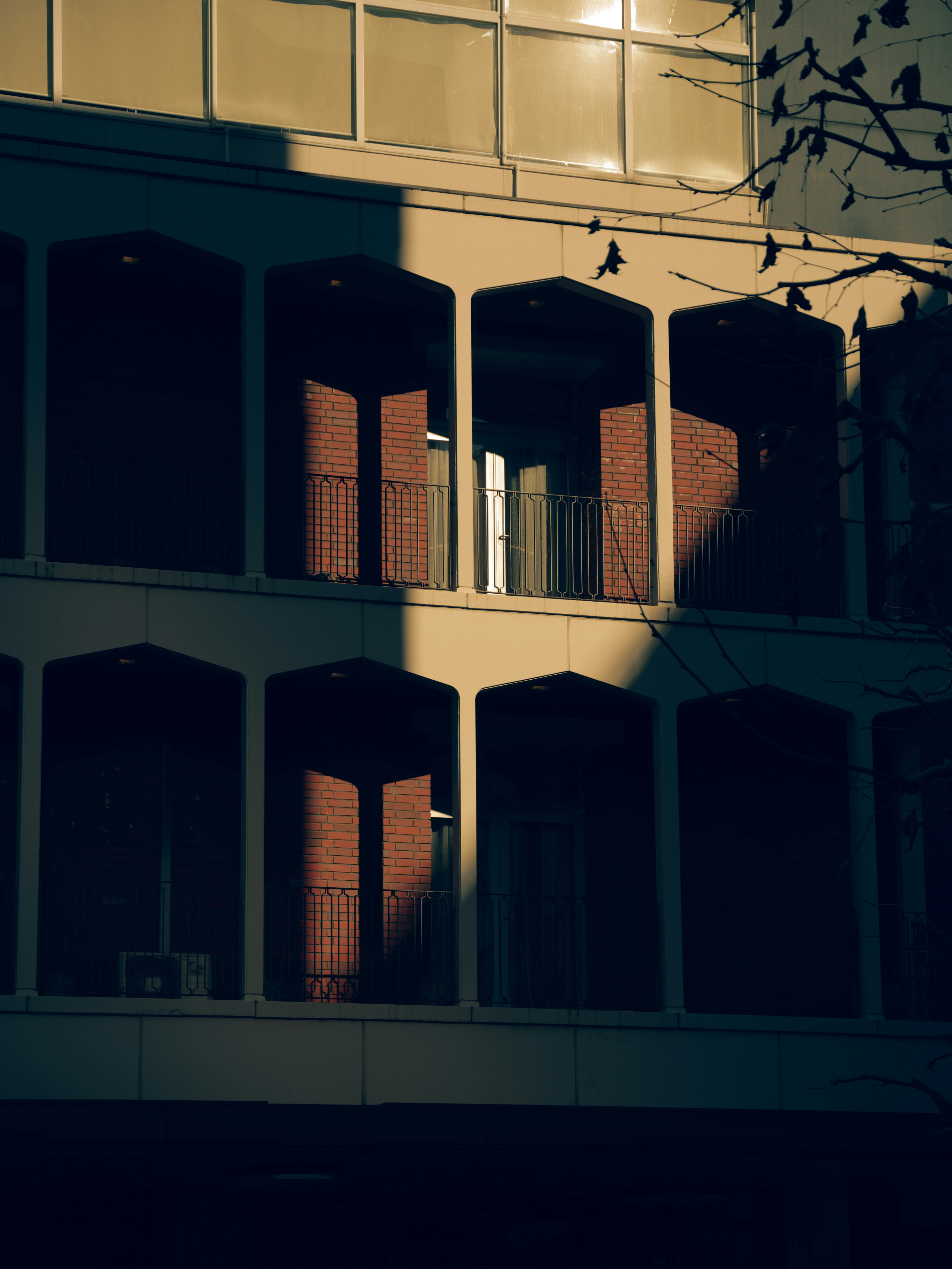 Exterior de un edificio con ventanas abiertas en la sombra