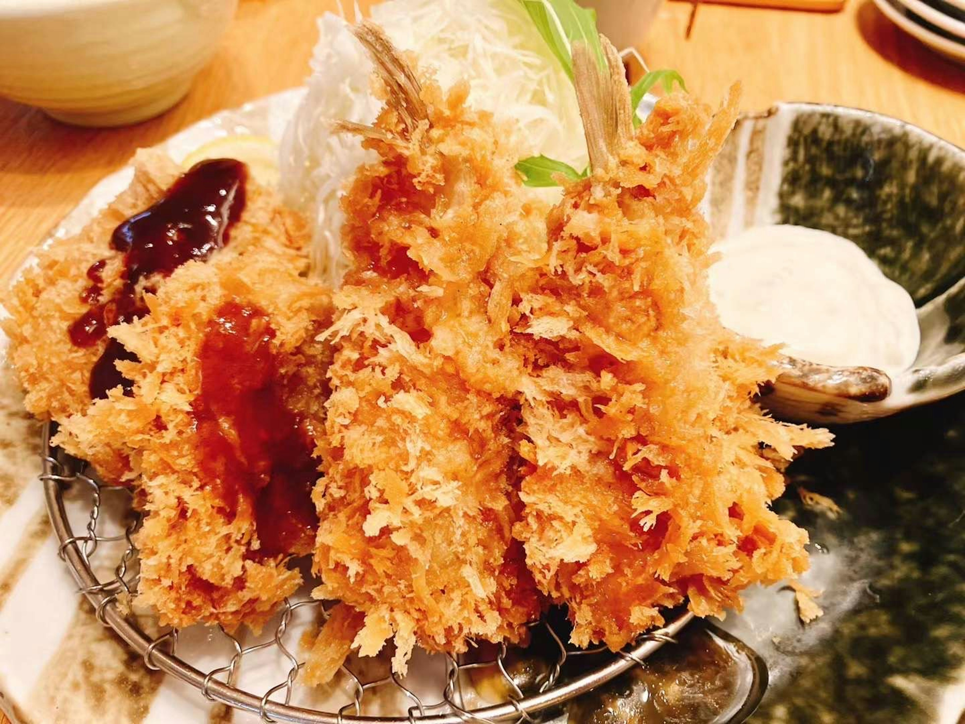 Crispy fried shrimp arranged on a plate with sauce